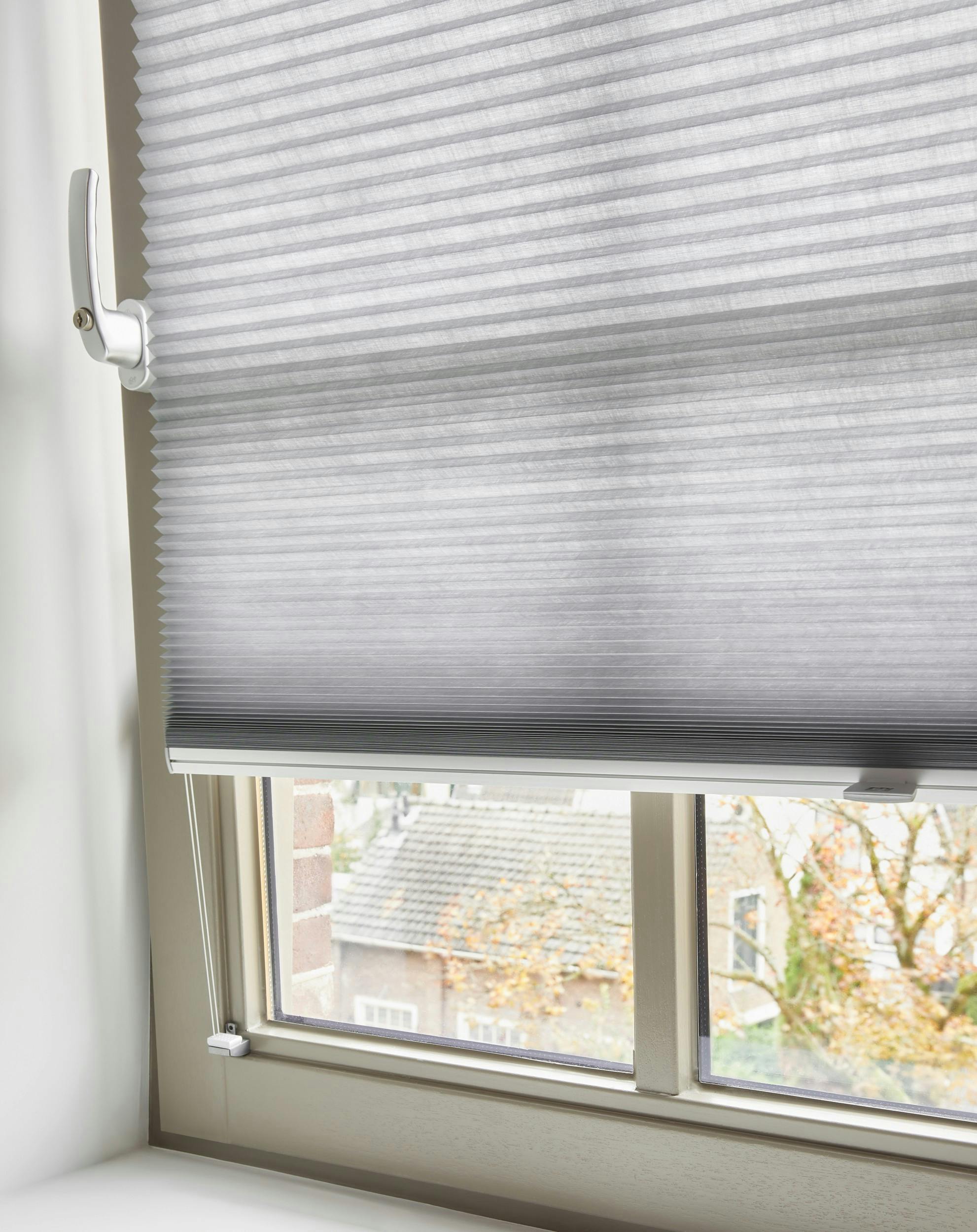 Light grey Duette® shades on a tilt & turn window