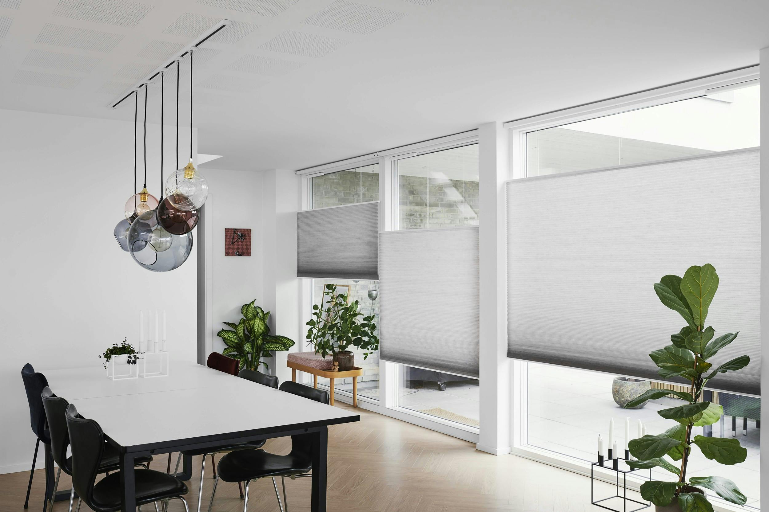 White dining room with light grey Duette® shades on windows
