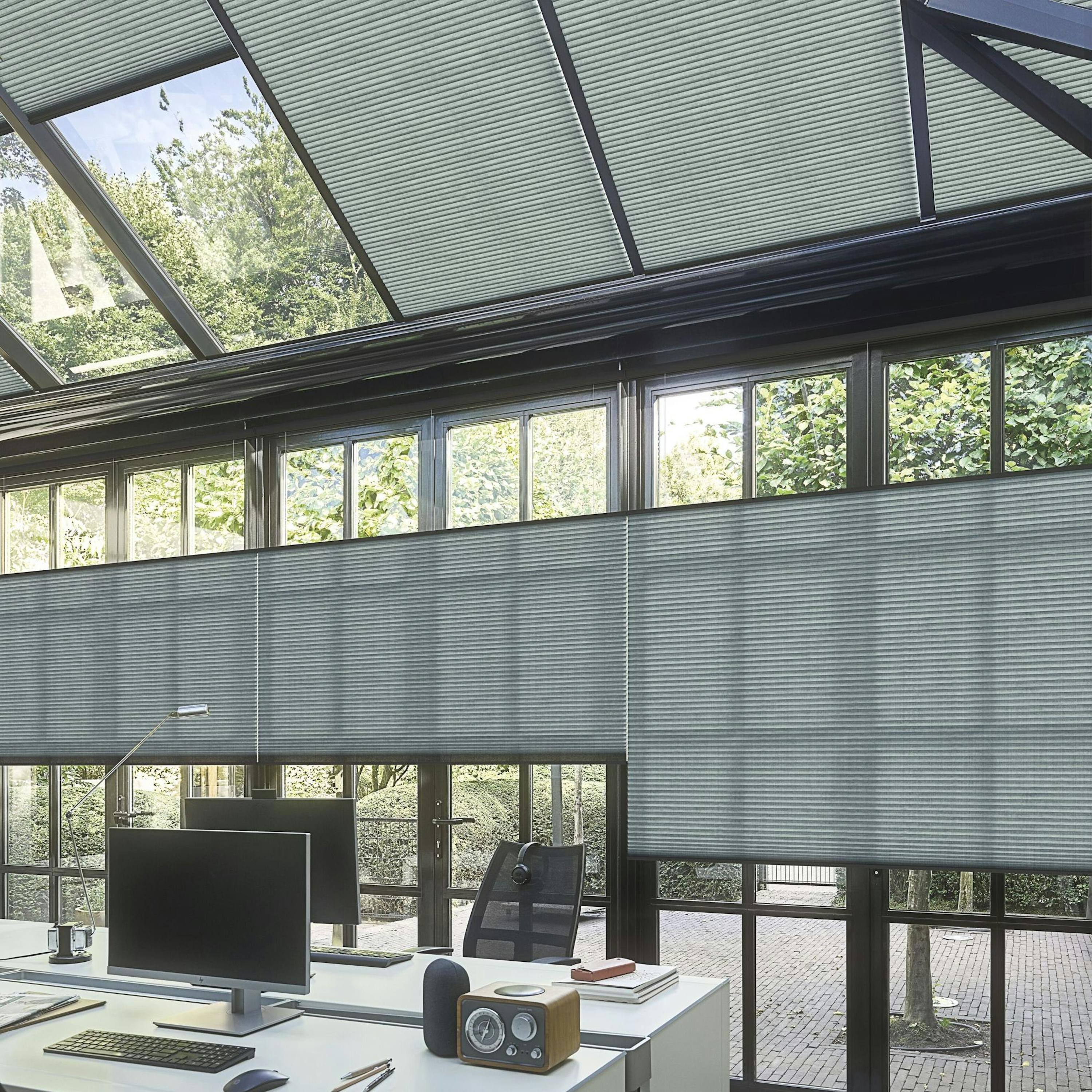 Dark green re-life duette shades on a conservatory home office