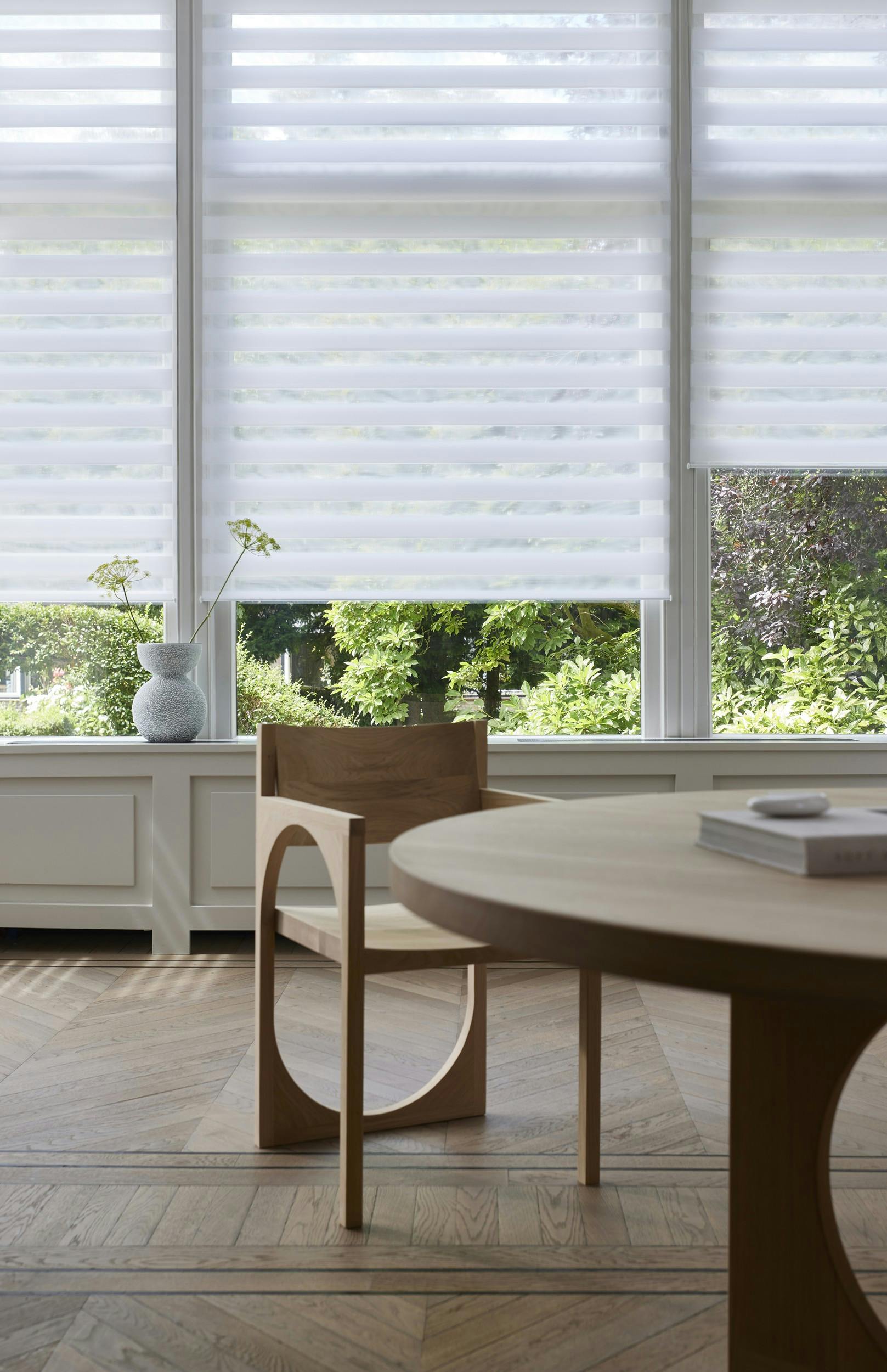 Stores enrouleurs duo blancs sur une fenêtre