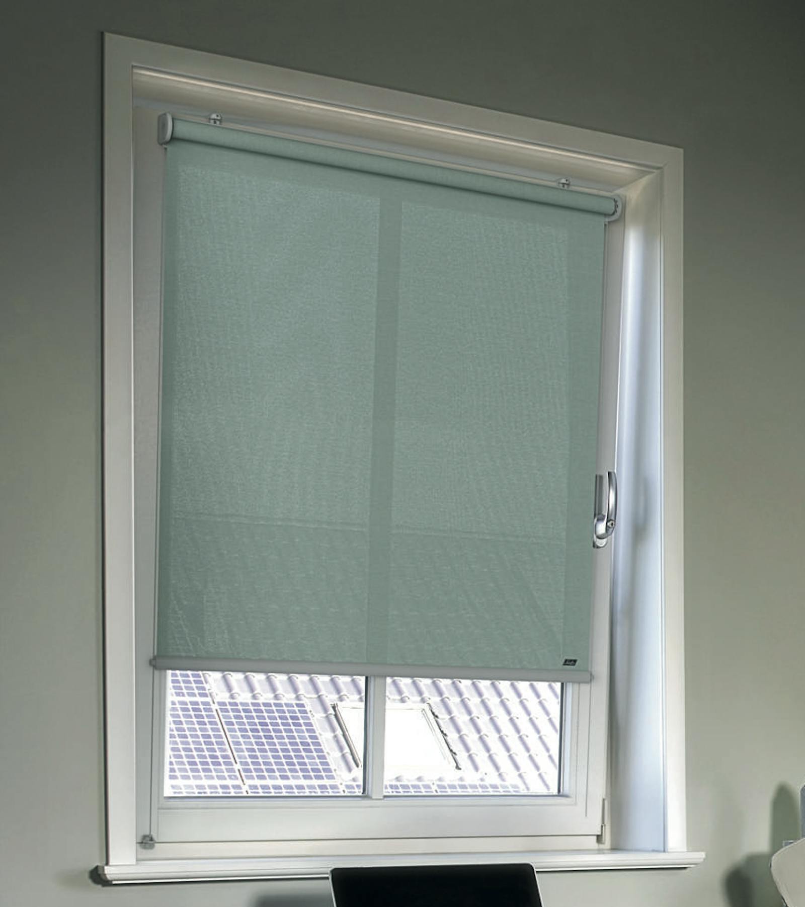 Gezellige thuiswerkplek met lichtgroene rolgordijnen op de ramen