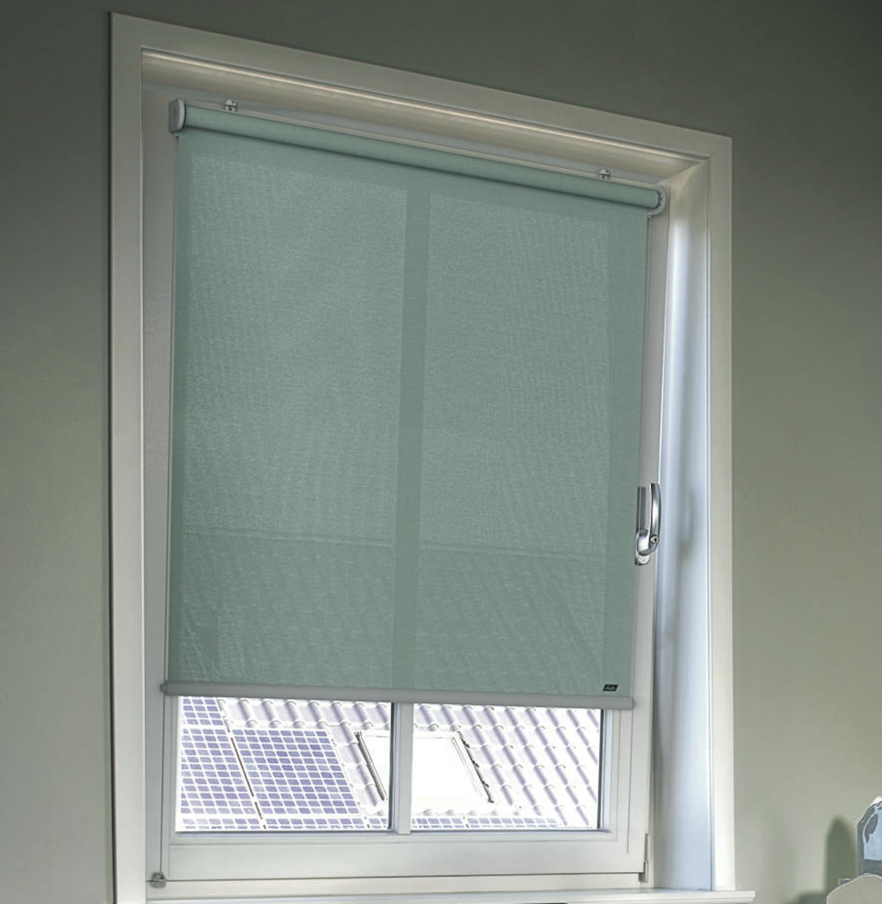 Koselig hjemmekontor med lyseblå rullegardiner på vinduene