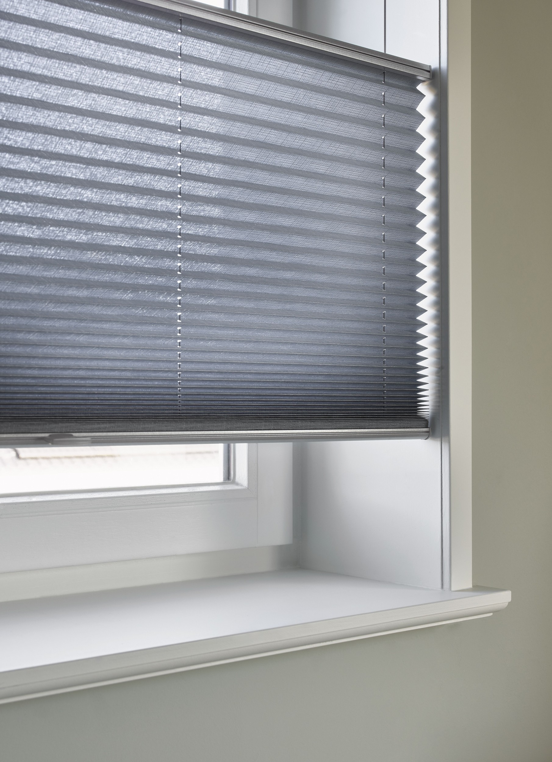 Gros plan sur des stores plissés bleus avec fonction Top down / Bottom up