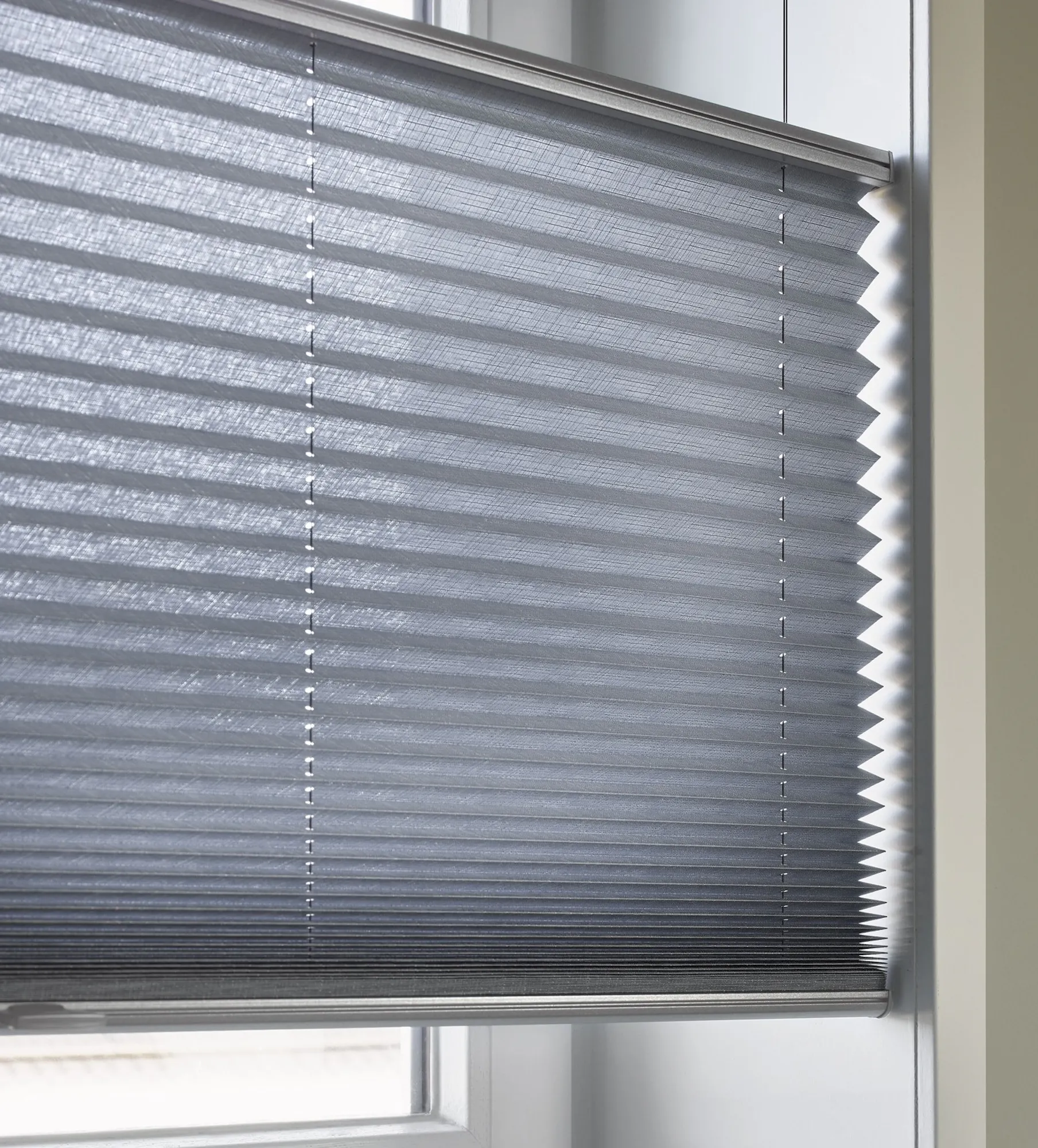 Närbild på blå plisségardiner med Top down / Bottom up-funktion