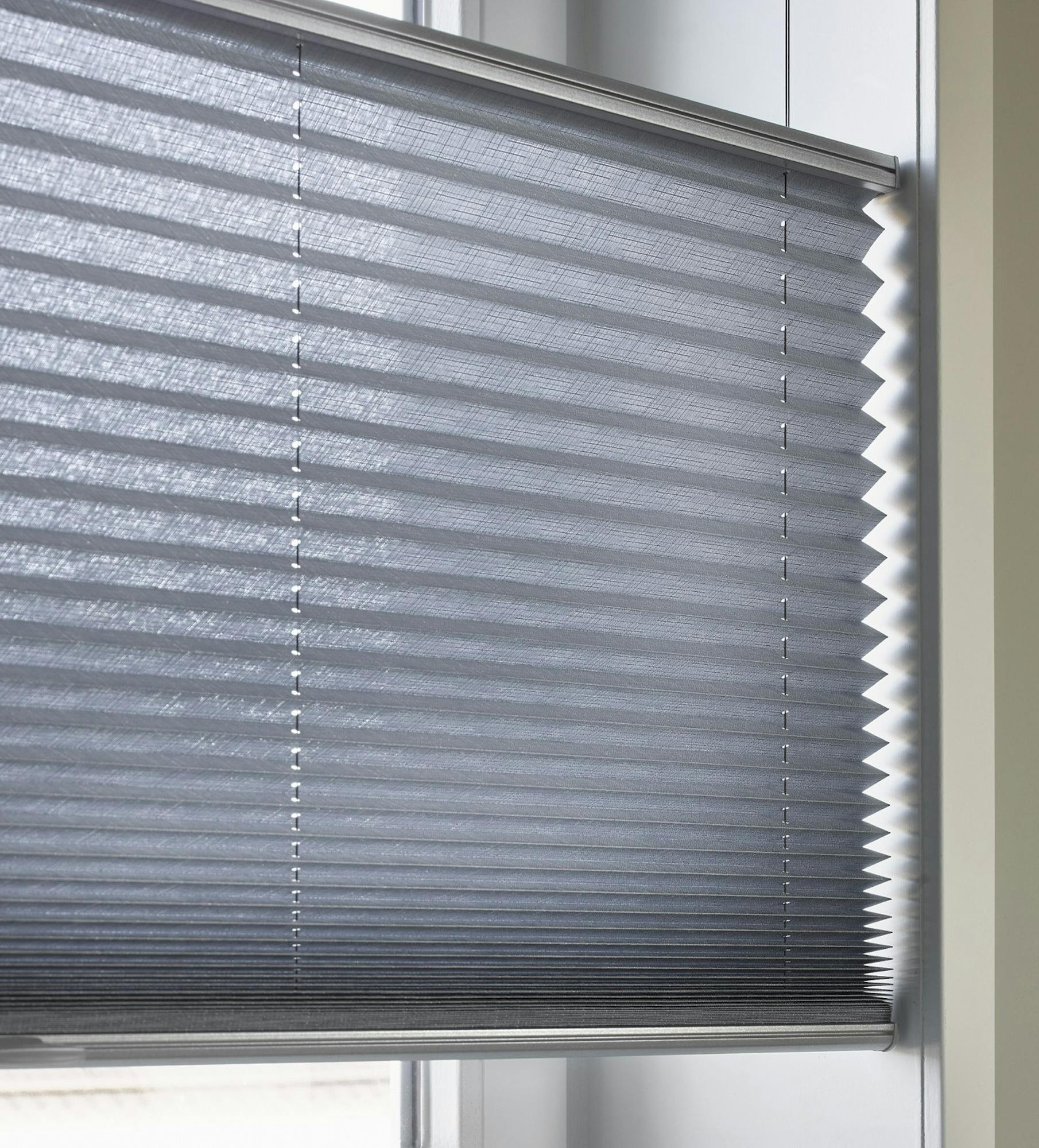 Nærbillede af blå plisségardiner med top down/bottom up-funktion