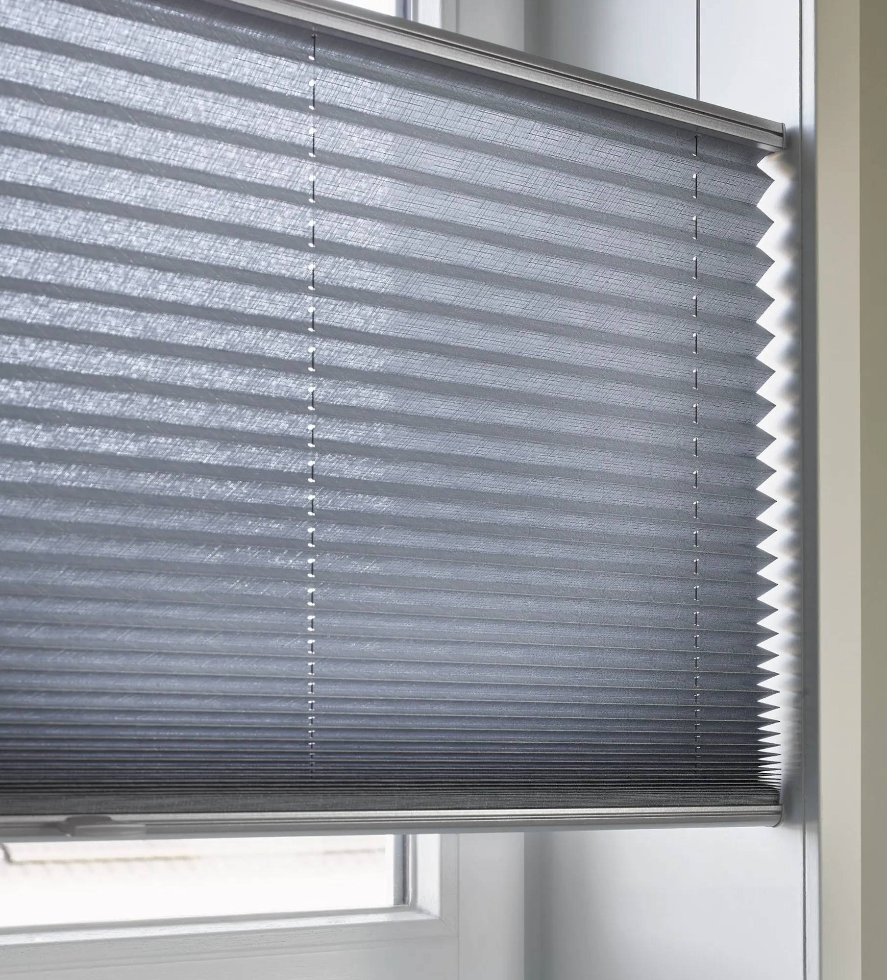 Nærbilde av blå plisségardiner med top down/bottom up-funksjon