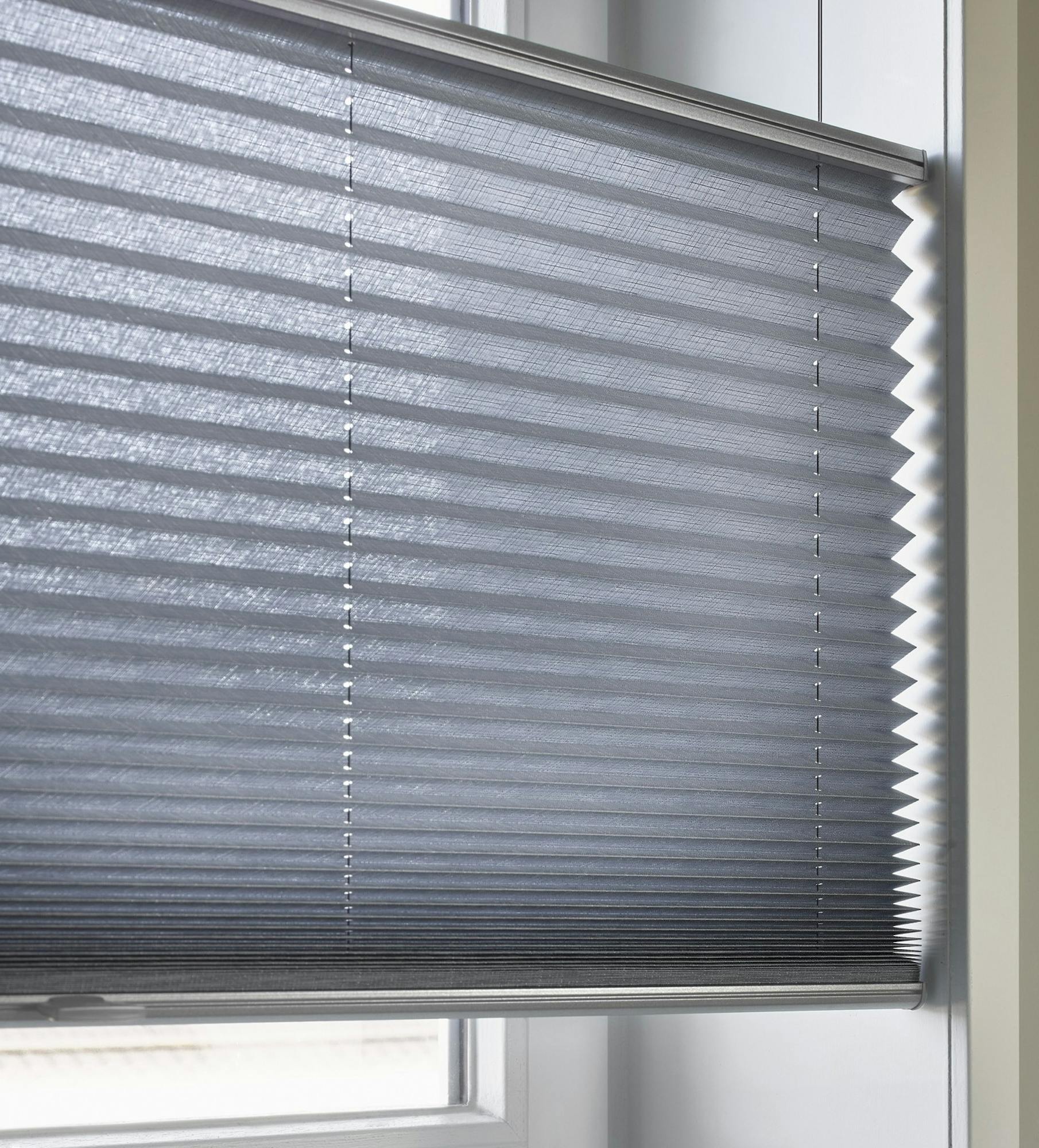 Gros plan sur des stores plissés bleus avec fonction Top down / Bottom up