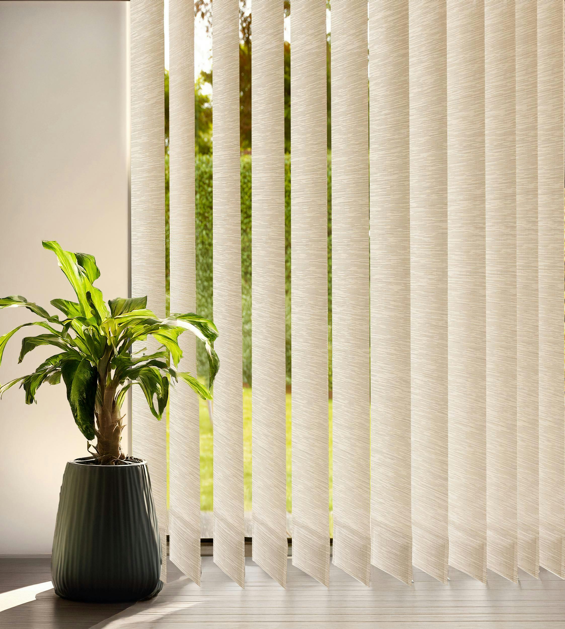 A close up of cream vertical blinds on a window and a plant next to it placed on the ground