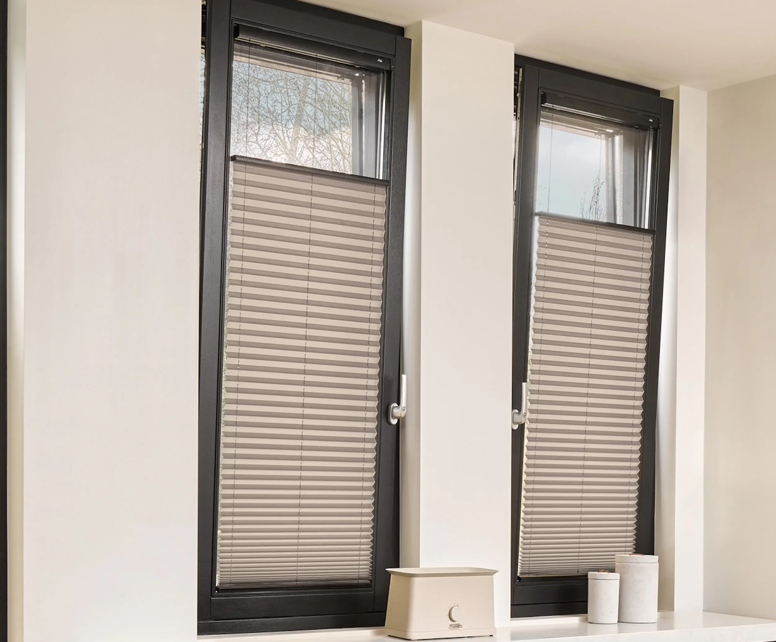 Grijze plissé shades op deur en ramen in een keuken