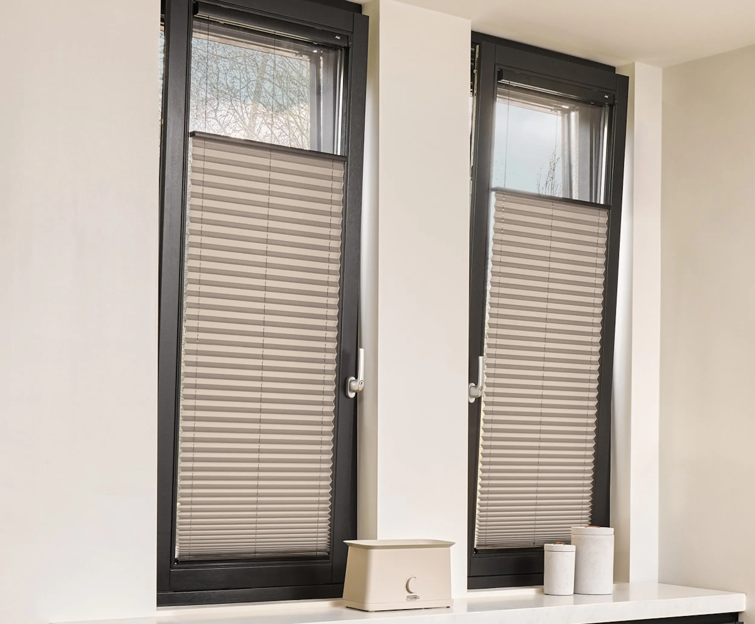 Grijze plissé gordijnen op deur en ramen in een keuken