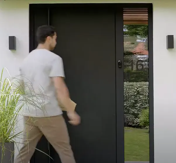 A man in front of house with a a smart door bell