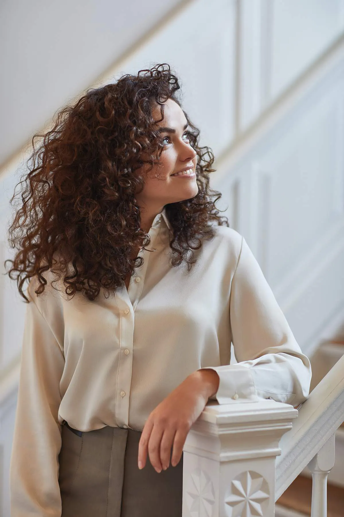 A woman looking towards the light standing on a staircase