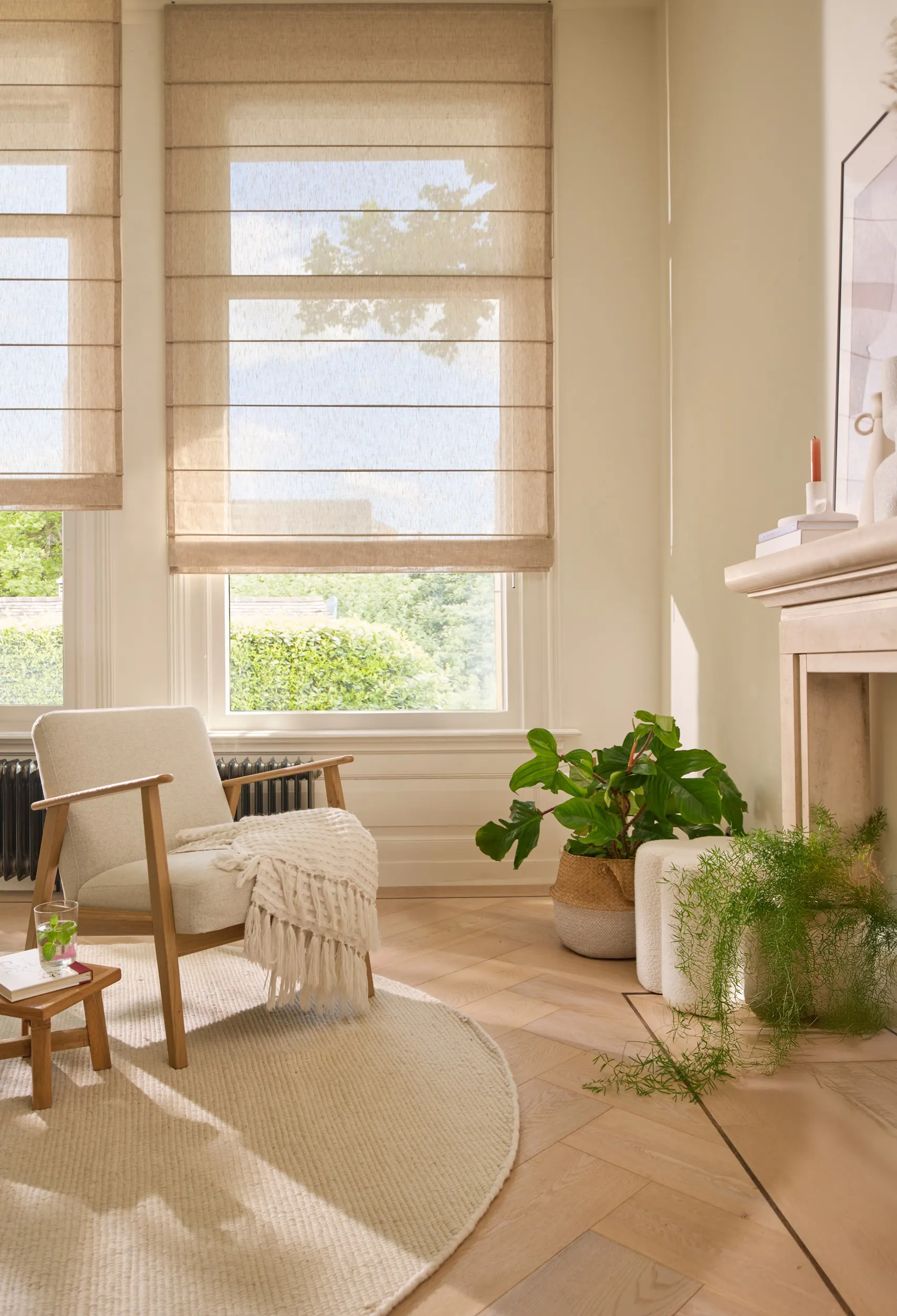 Lichte woonkamer met crèmekleurige vouwgordijnen op de ramen