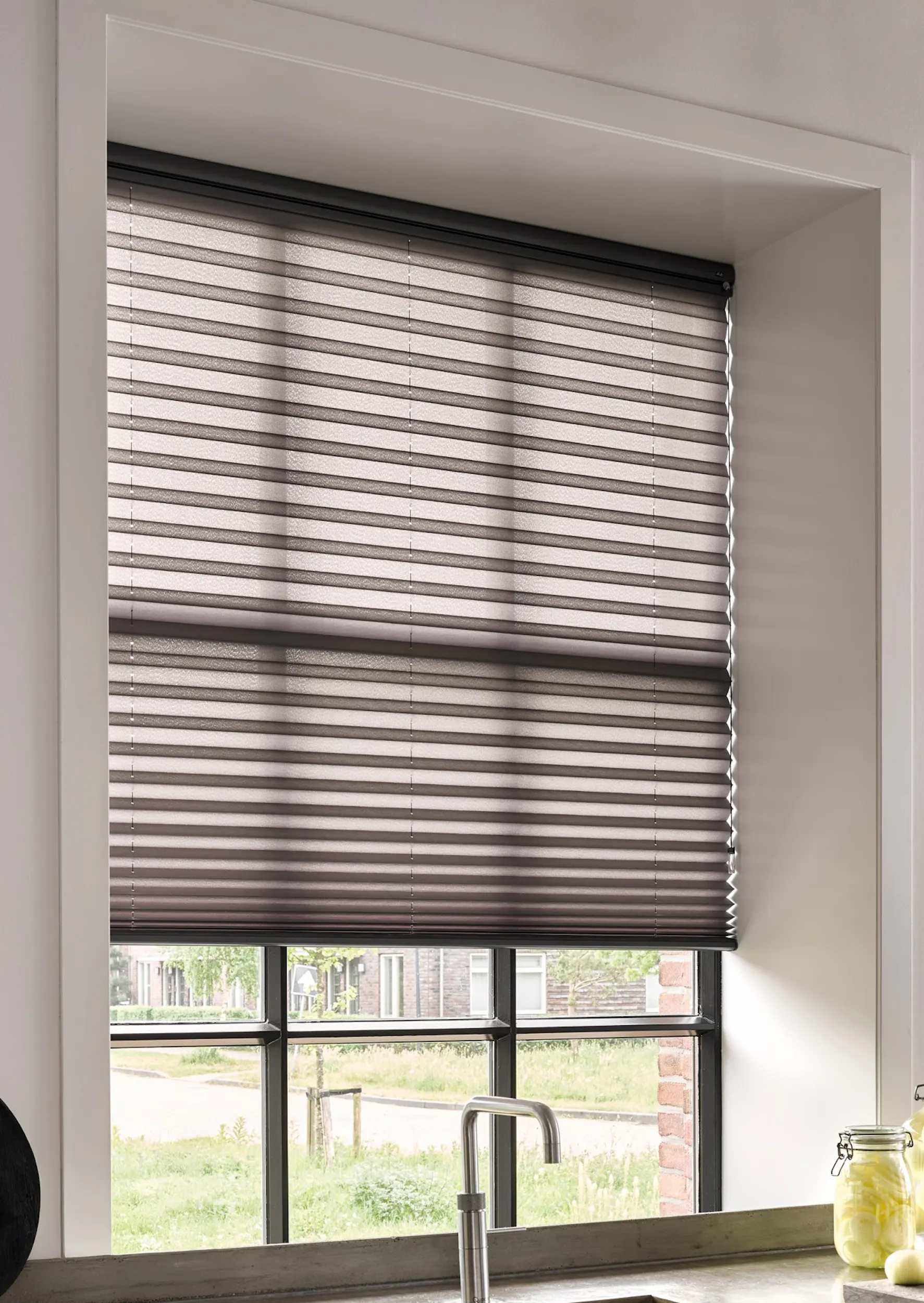 Stores plissés noirs sur une fenêtre de cuisine