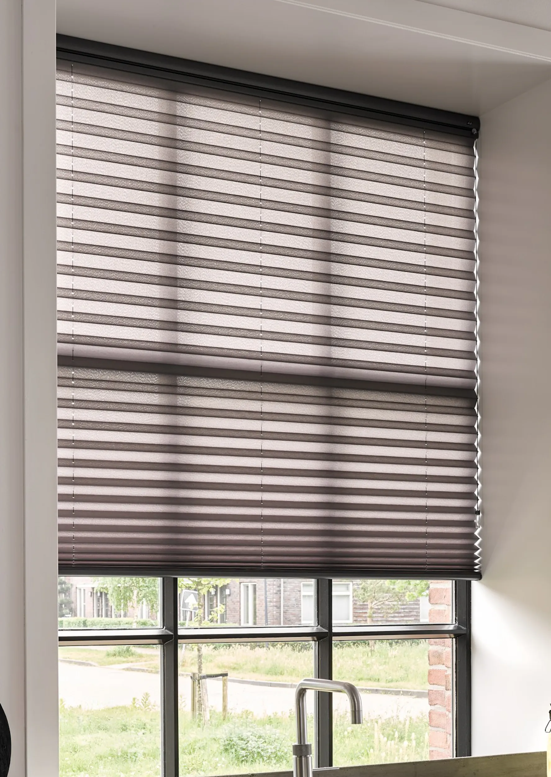 Zwarte plissé shades op een keukenraam