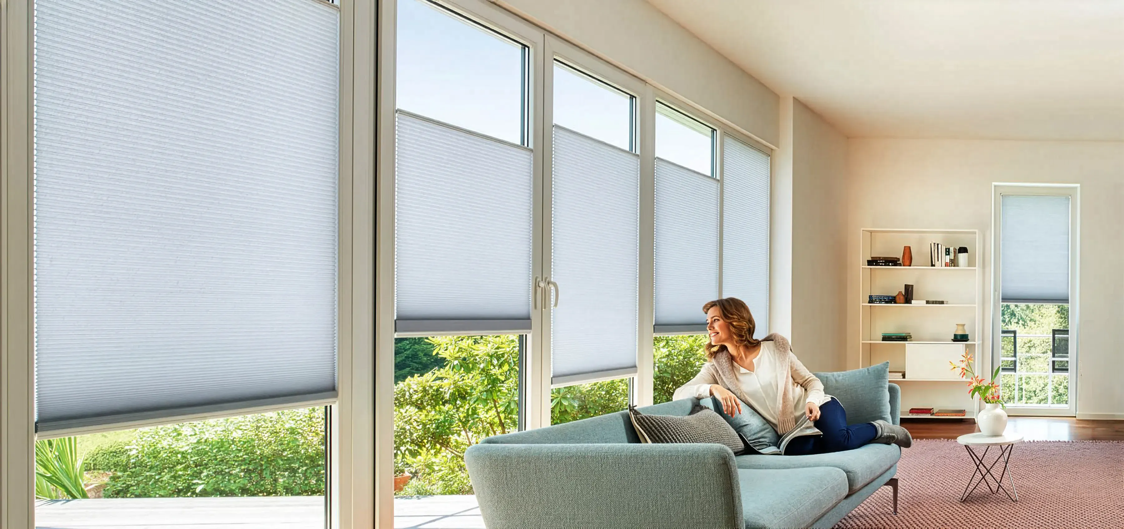Light blue honeycomb blinds on large windows in a living room 