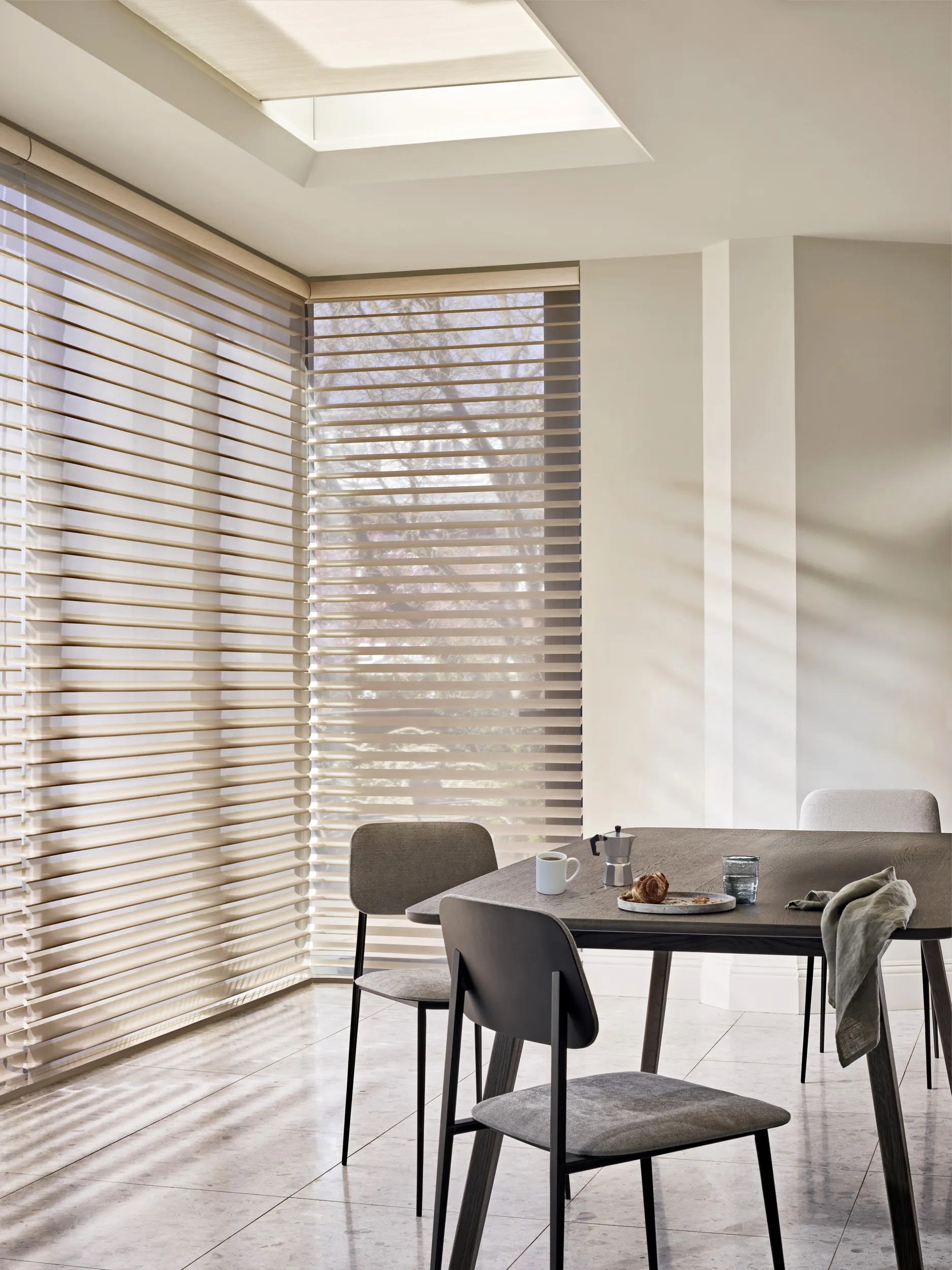 Lys spisestue med cremefarvede Silhouette® gardiner i vinduerne