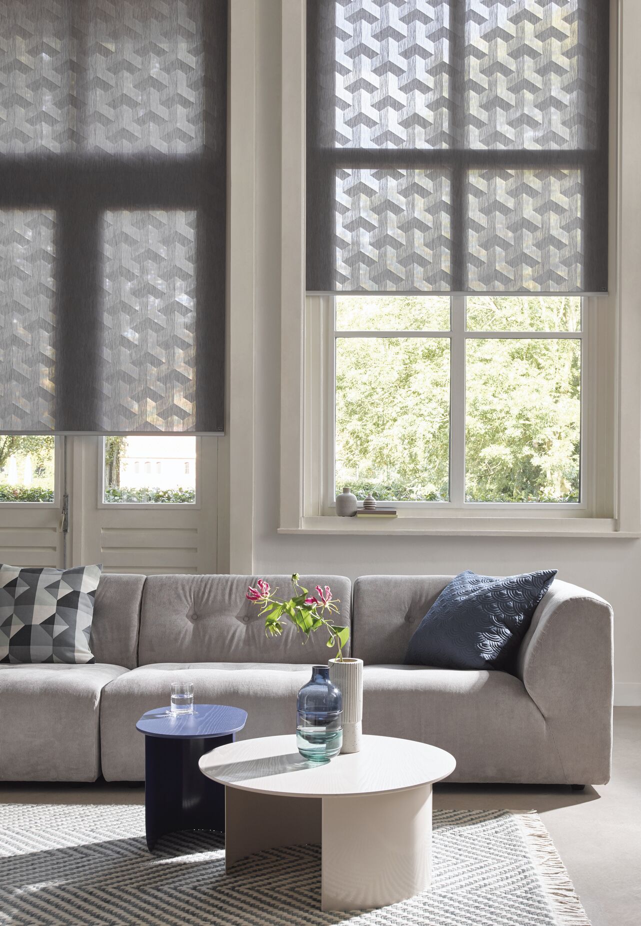 Blue roller blinds with white geometric designs  in a living room