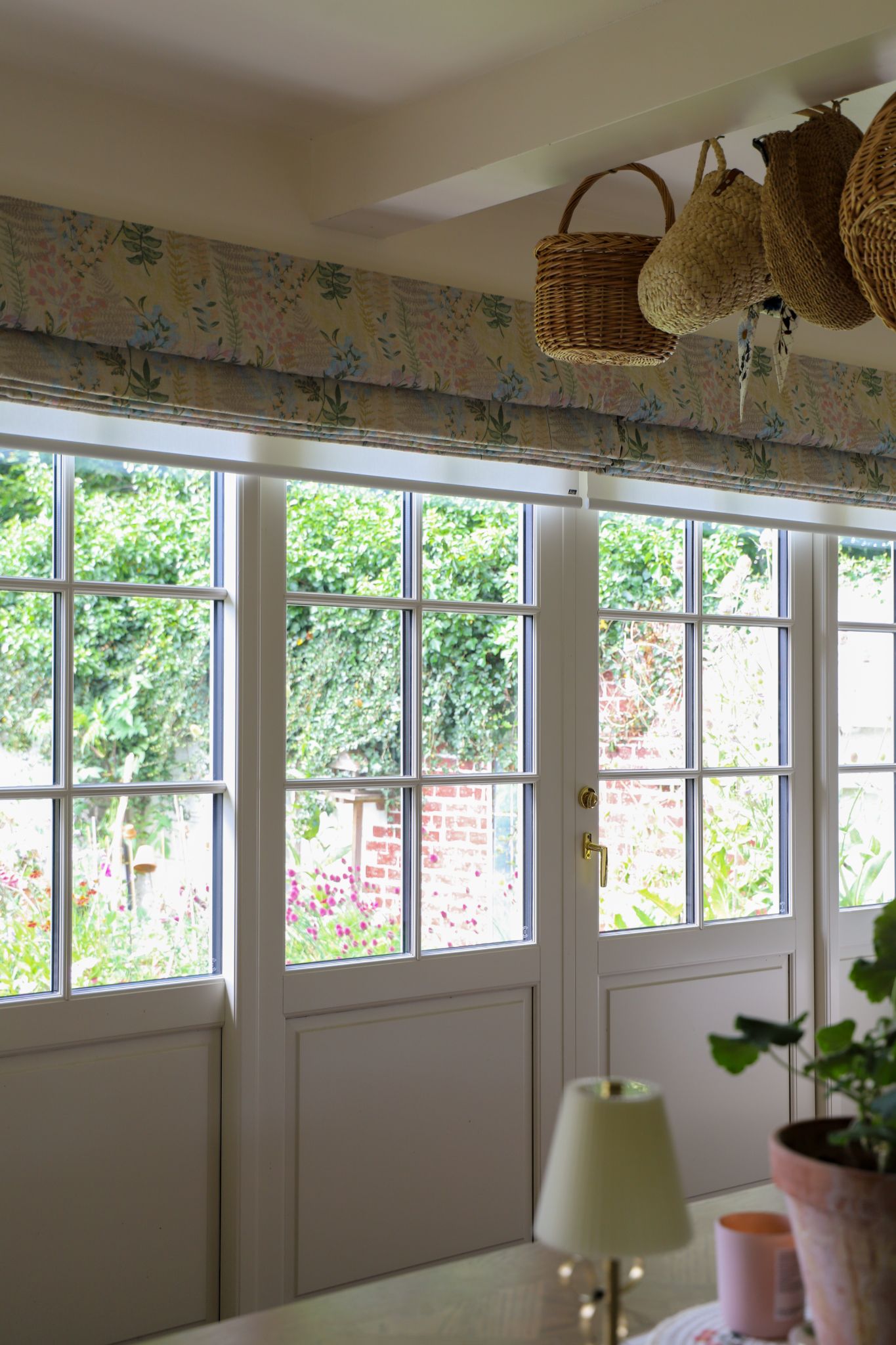 Colourful patterned roman blinds in an open position in a cosy living area