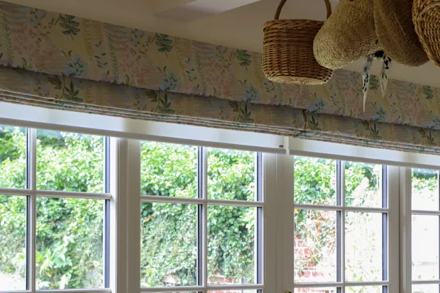 Colourful patterned roman blinds in an open position in a cosy living area