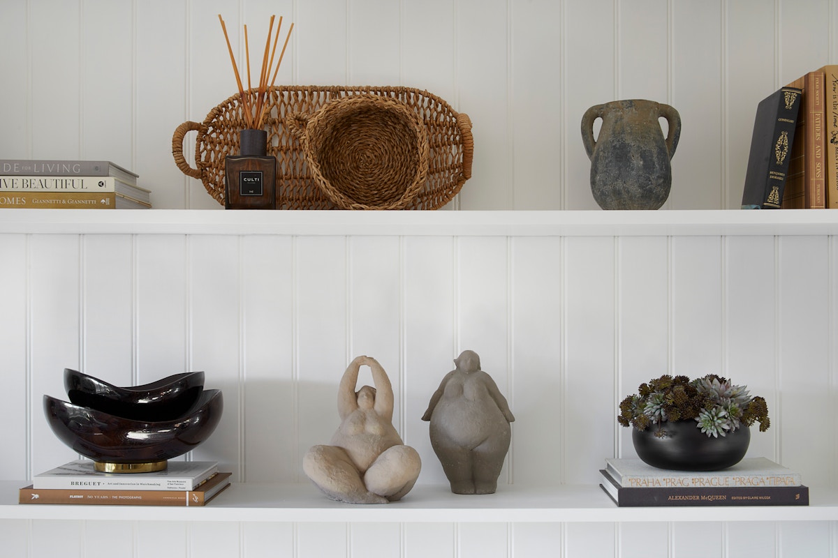 Shelf styling with intersting sculptures, bowls and diffuser