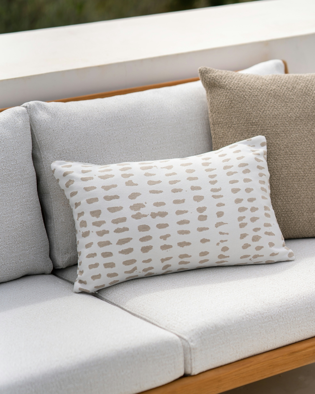 Closeup image of the outdoor Dots cushion set of 2 with square boucle outdoor cushion in oat