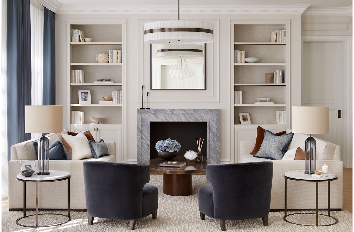 Classic contemporary living room by designer Andrea Benedettini in blue and white, two blue velvet armchairs, marble side tables and white sofas