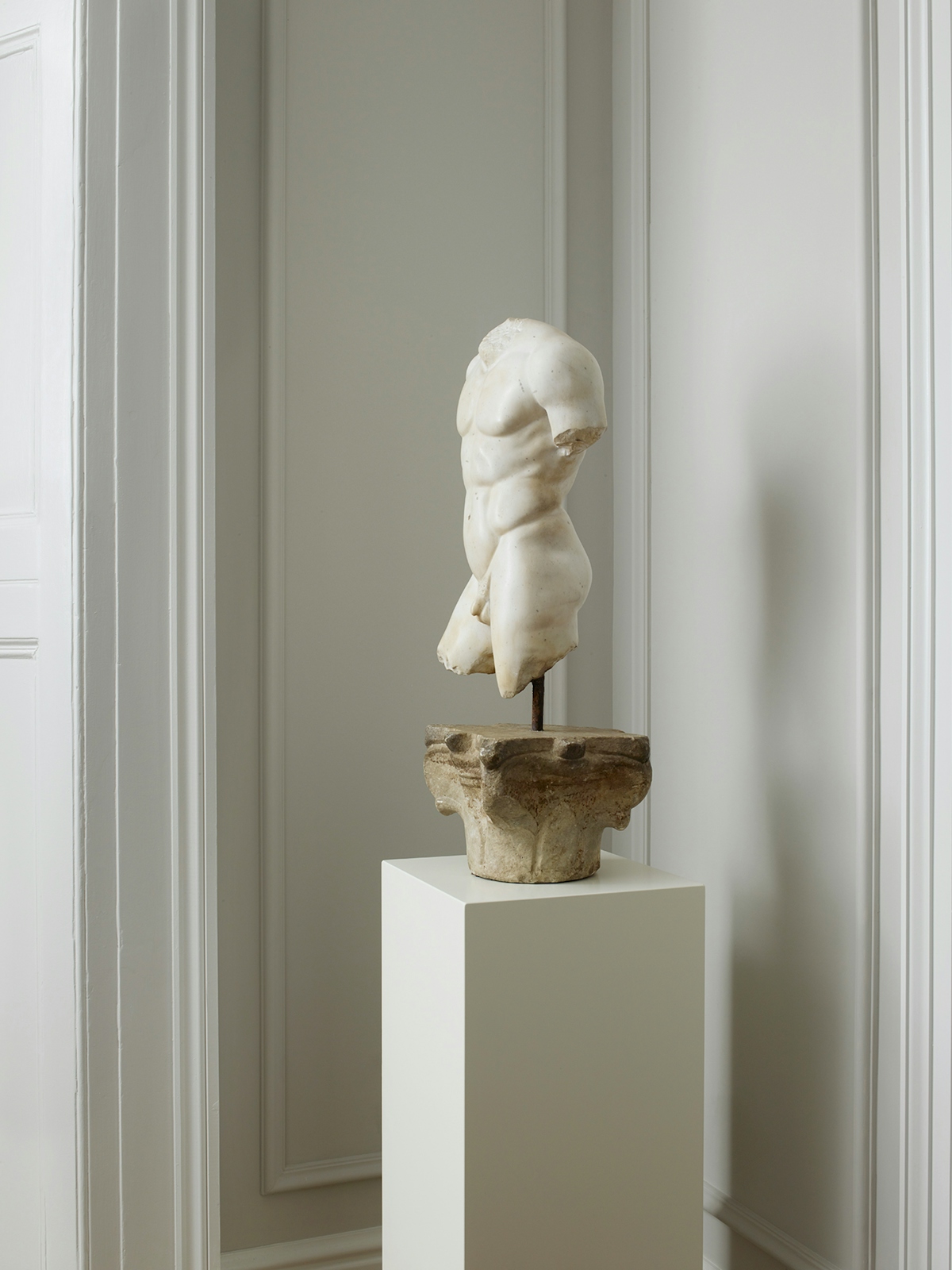 White Roman sculpture on a pedestal in a corner by Banda Property | The Quiet Luxury Lookbook