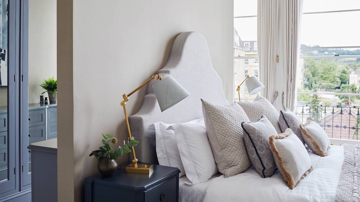 Emma Sims-Hilditch bedroom with bespoke headboard and brass bedside lamps 