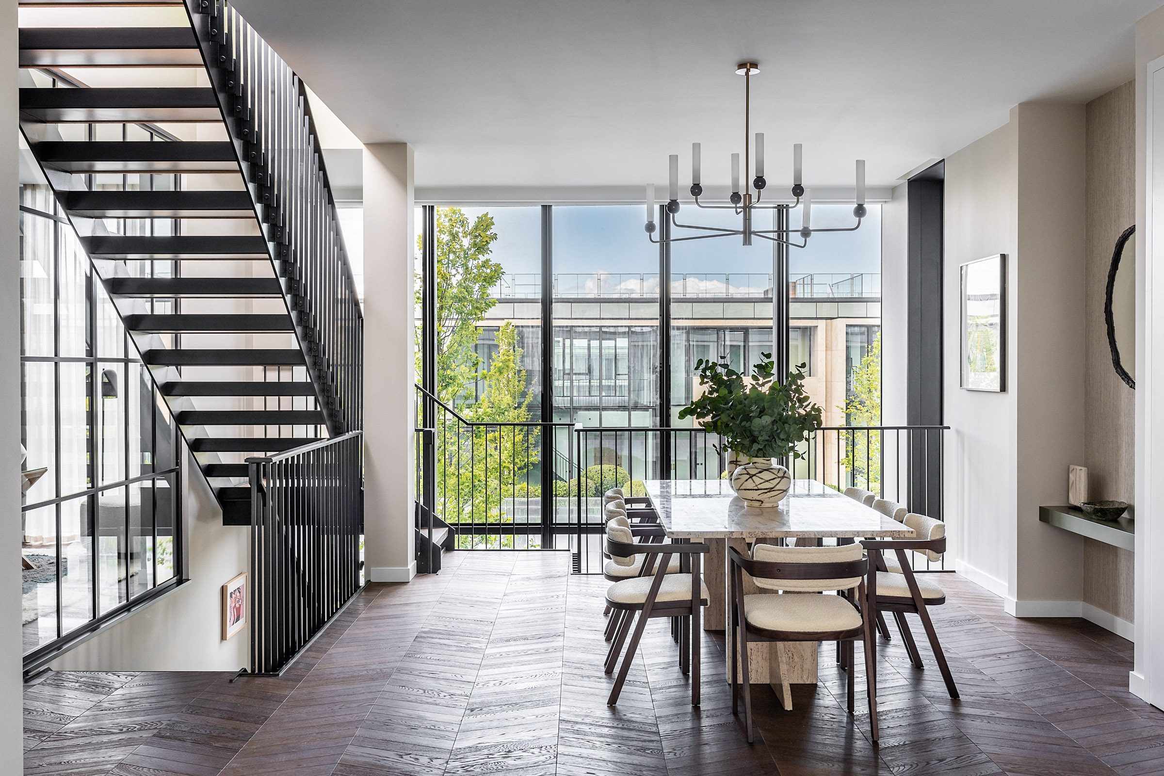 Natalia Miyar Sky Villa interior dining room with large chandelier and metal staircase