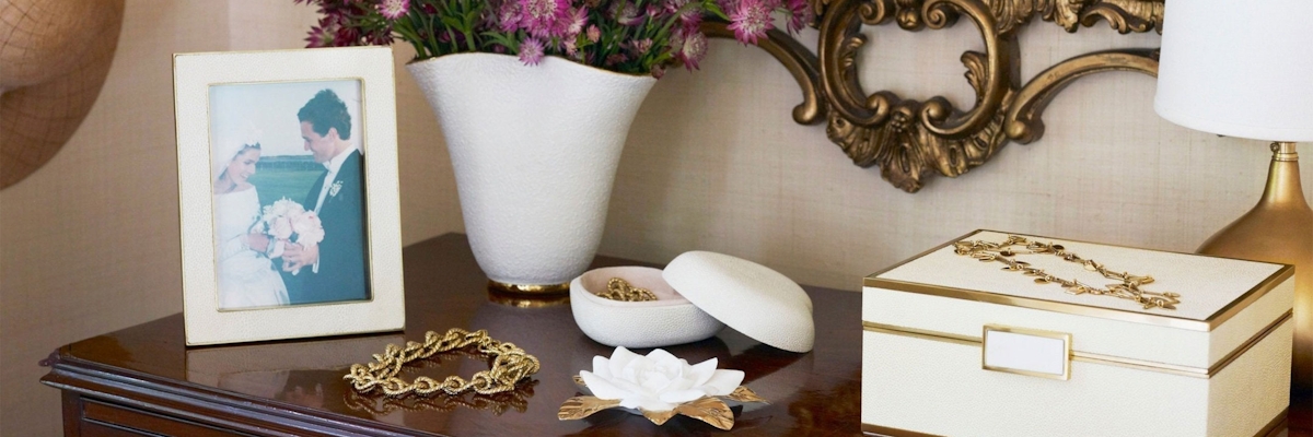 Aerin cream shagreen collection with photo frame and jewellery box atop at dresser with vase of pink flowers