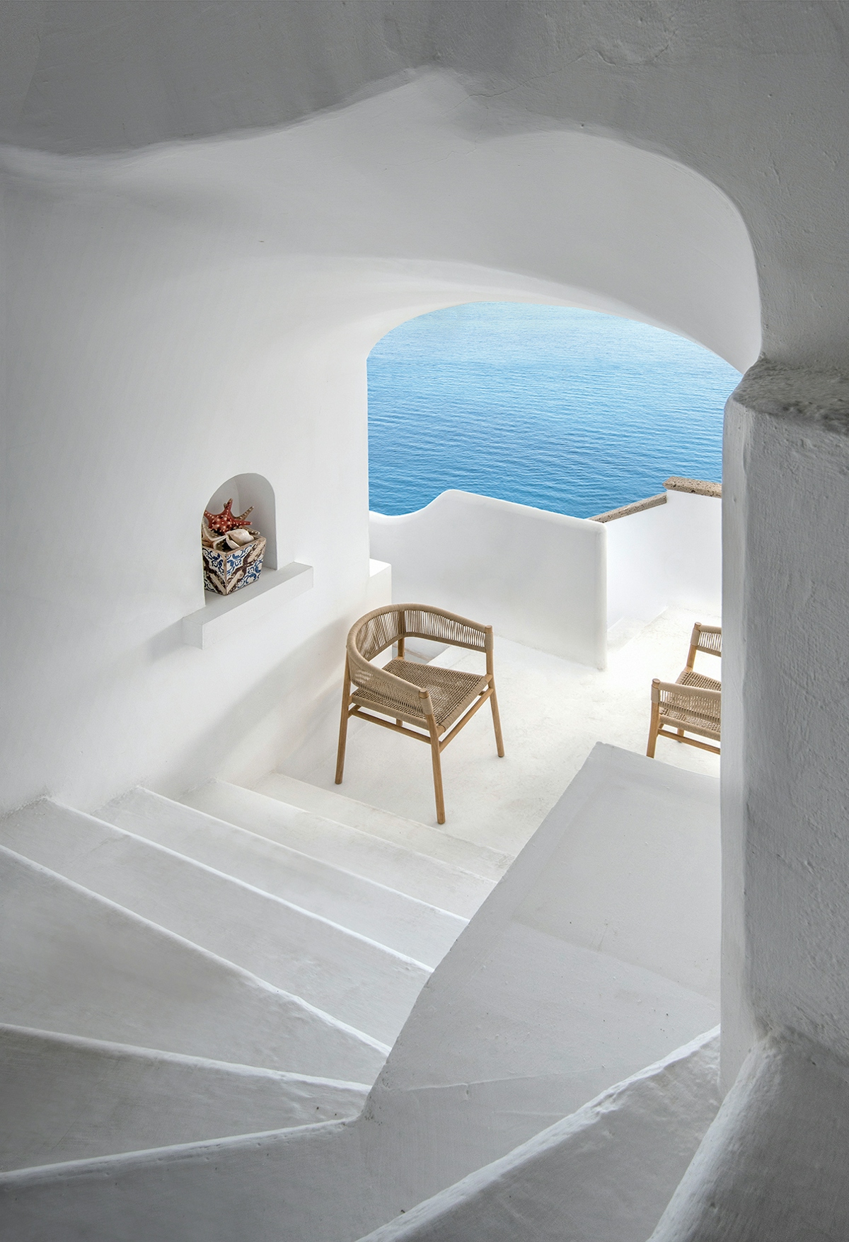Ethimo Kilt outdoor dining chair in Greek minimalist setting beside the sea