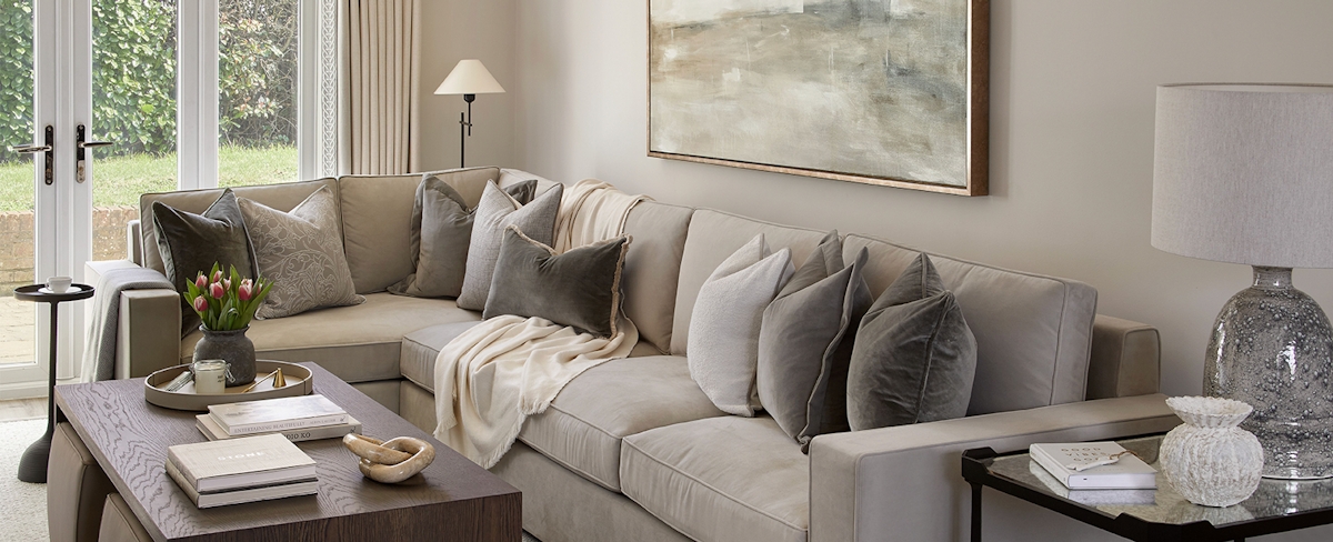 The Modern Lookbook, living room, luxury corner sofa and cushion spread with wood coffee table.