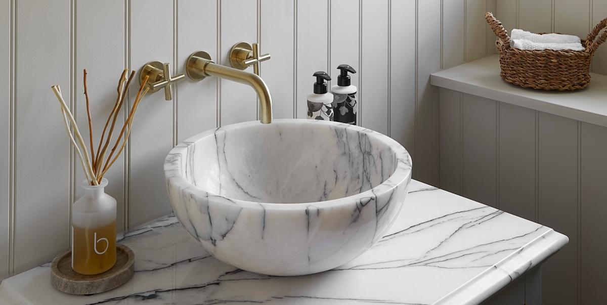 Attractive marble basin sink on marble countertop with brass hardware details