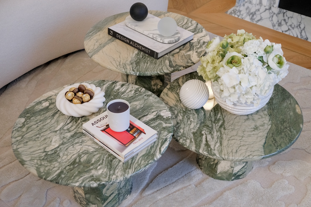 Camilla Carril green marble vintage coffee table with styled accessories including candles, coffee table books, faux florals and stone objects.