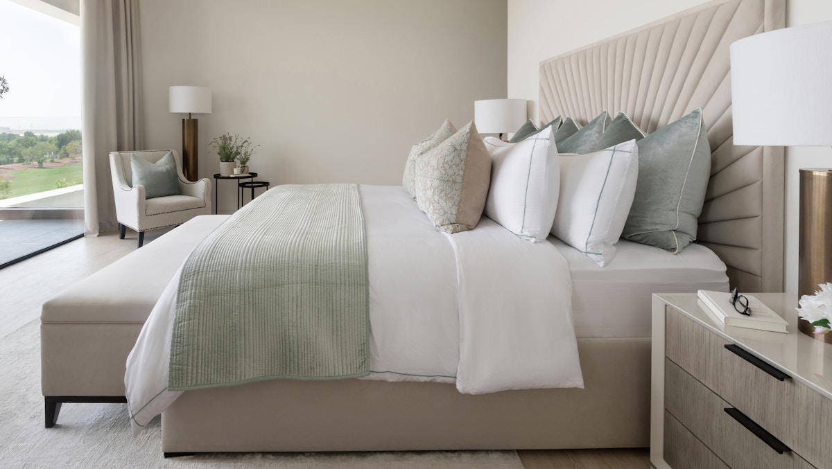 Calming bedroom with muted colour tones, upholstered bed with end of bed bench