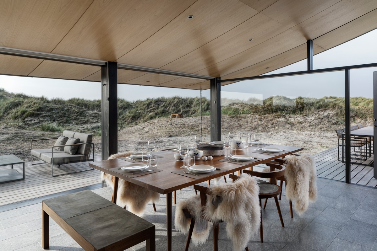 Tollgard Studios scandi designed dining room with natural wood dining table and chairs with fur throws