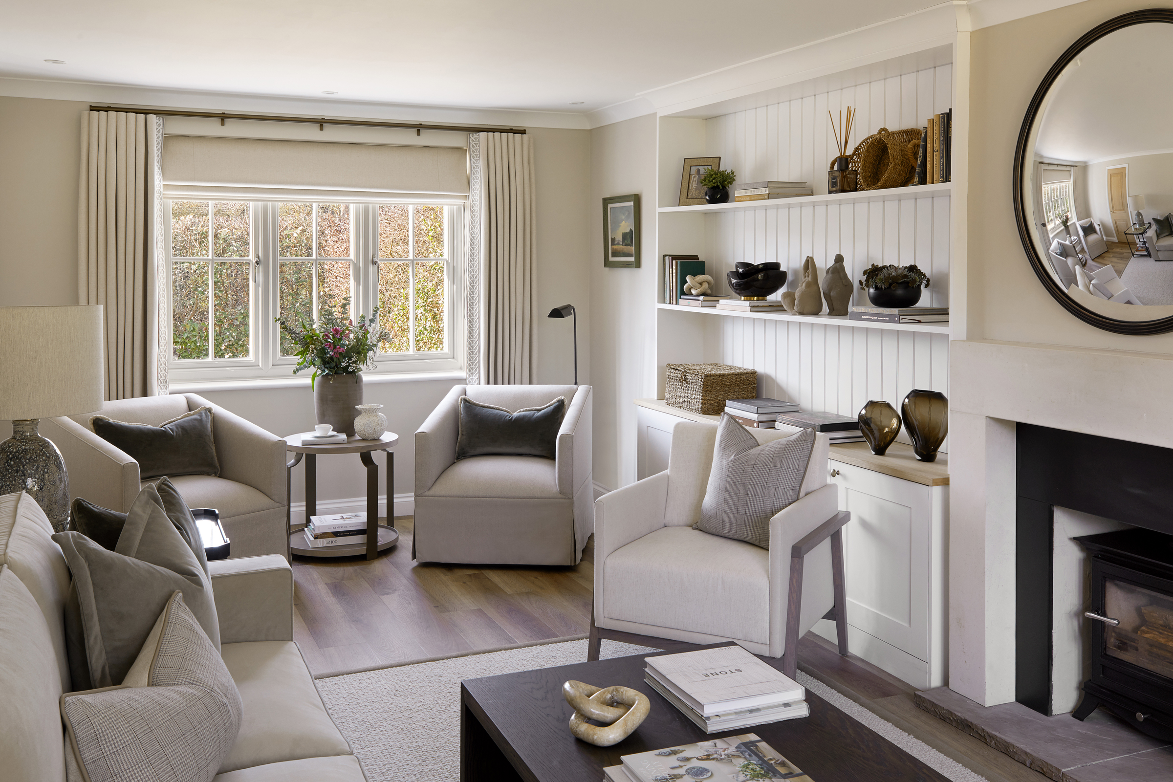 Modern country style linen Keswick Swivel Armchair by LuxDeco and Dakota side table by Loom, fresh flowers in rustic vase and large window