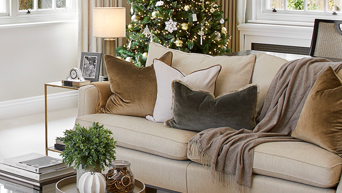 Luxury living room at Christmas featuring a tree with designer decorations, an open fireplace, beautiful furniture, home decor and accessories