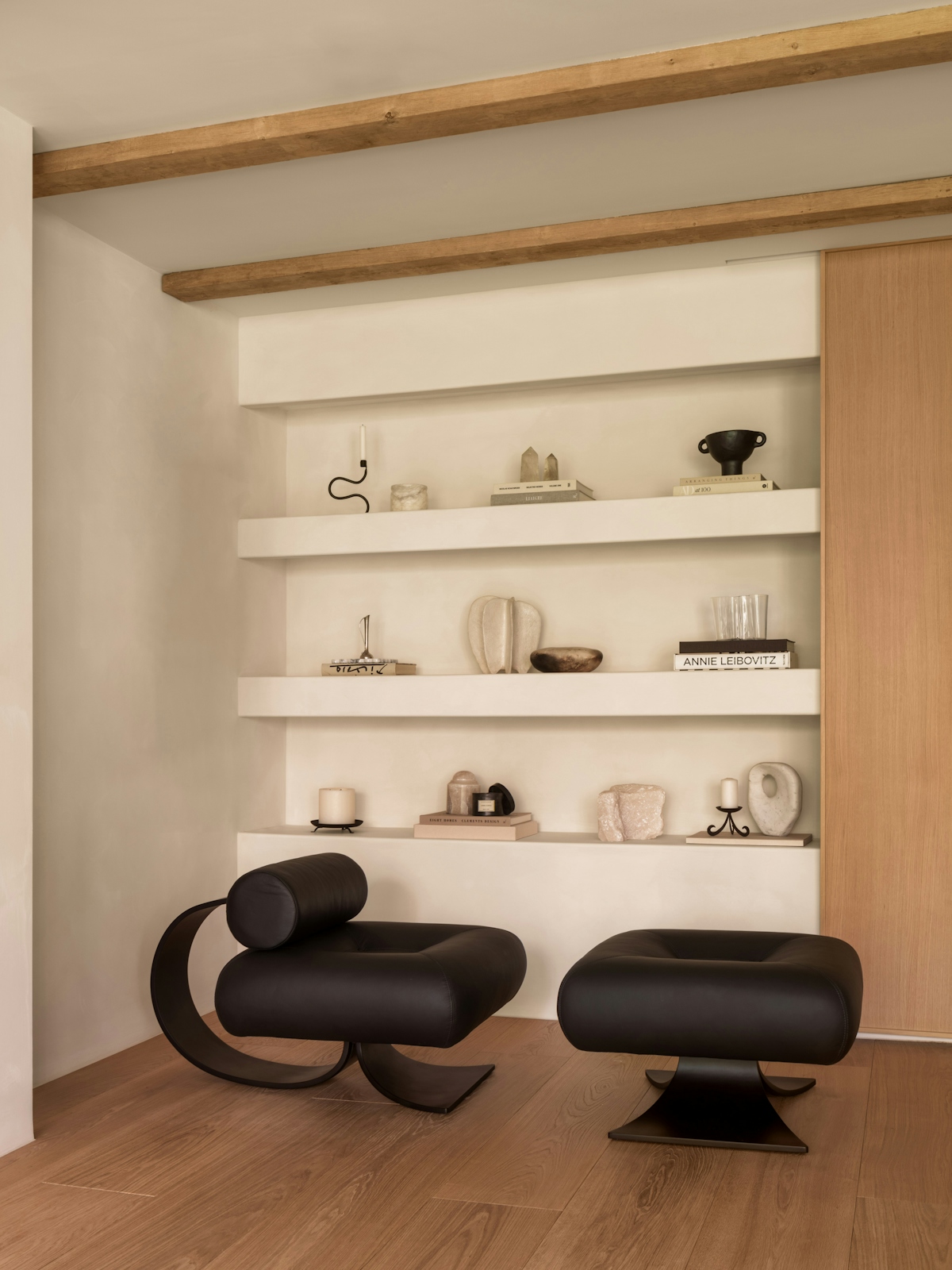 Covet Noir shelving with abstract ornaments and two minimalist black stools