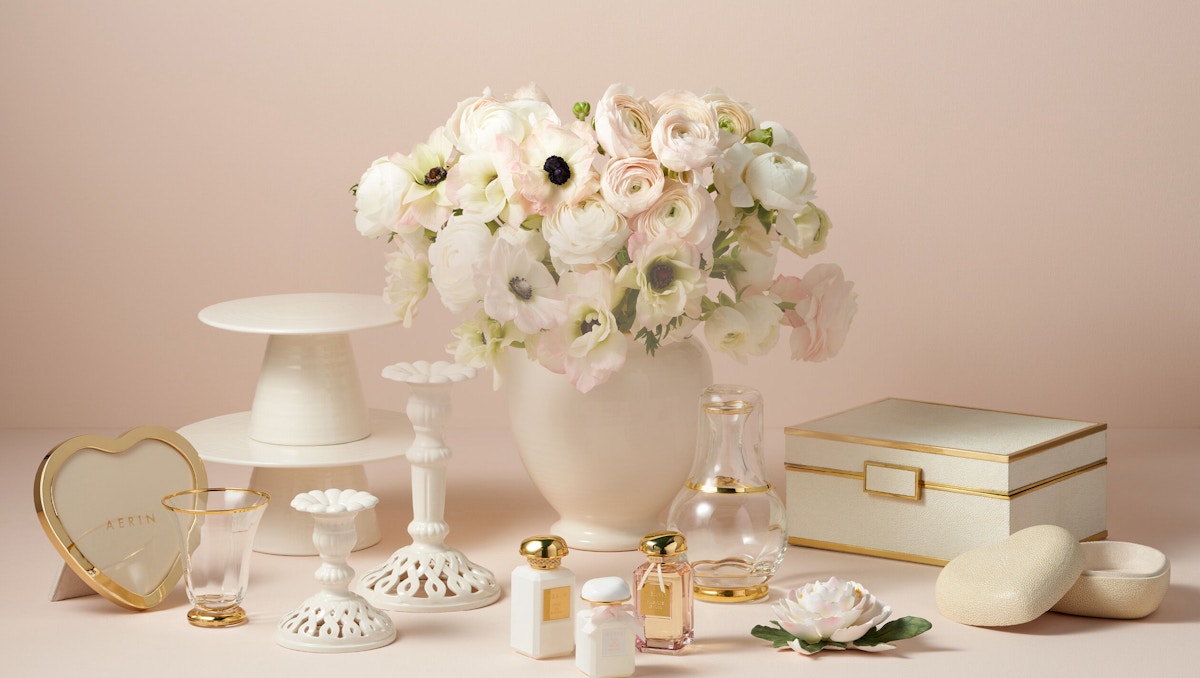 Aerin collection of cream and gold home accessories against a light pink backdrop