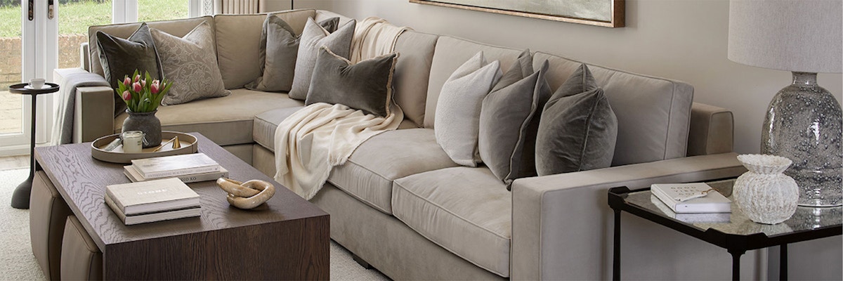 The Modern Lookbook, living room, luxury corner sofa and cushion spread with wood coffee table.
