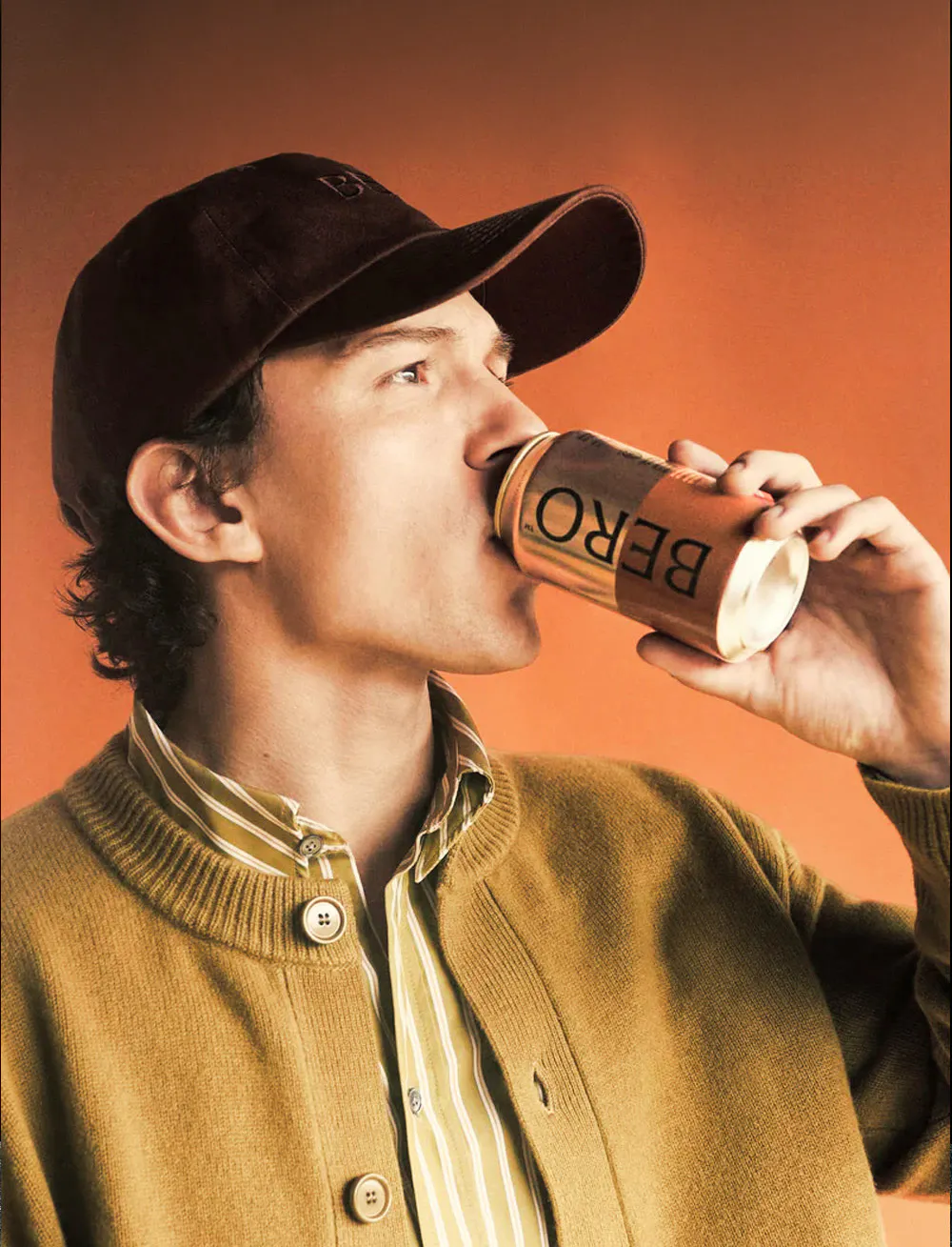 Man drinking a BERO non-alcoholic beer against an orange backdrop