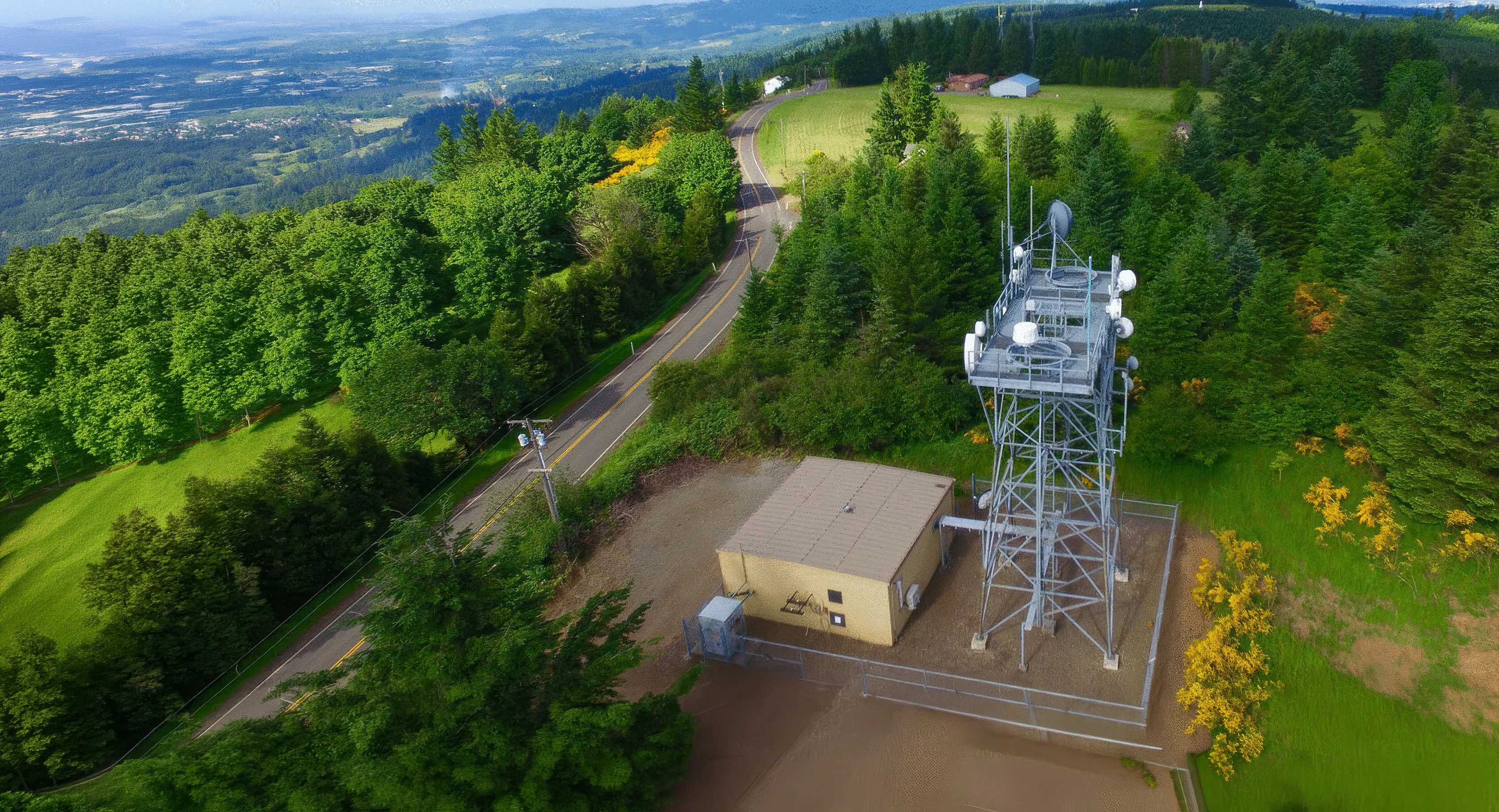 Aerial view of a communications tower on a forested hillside