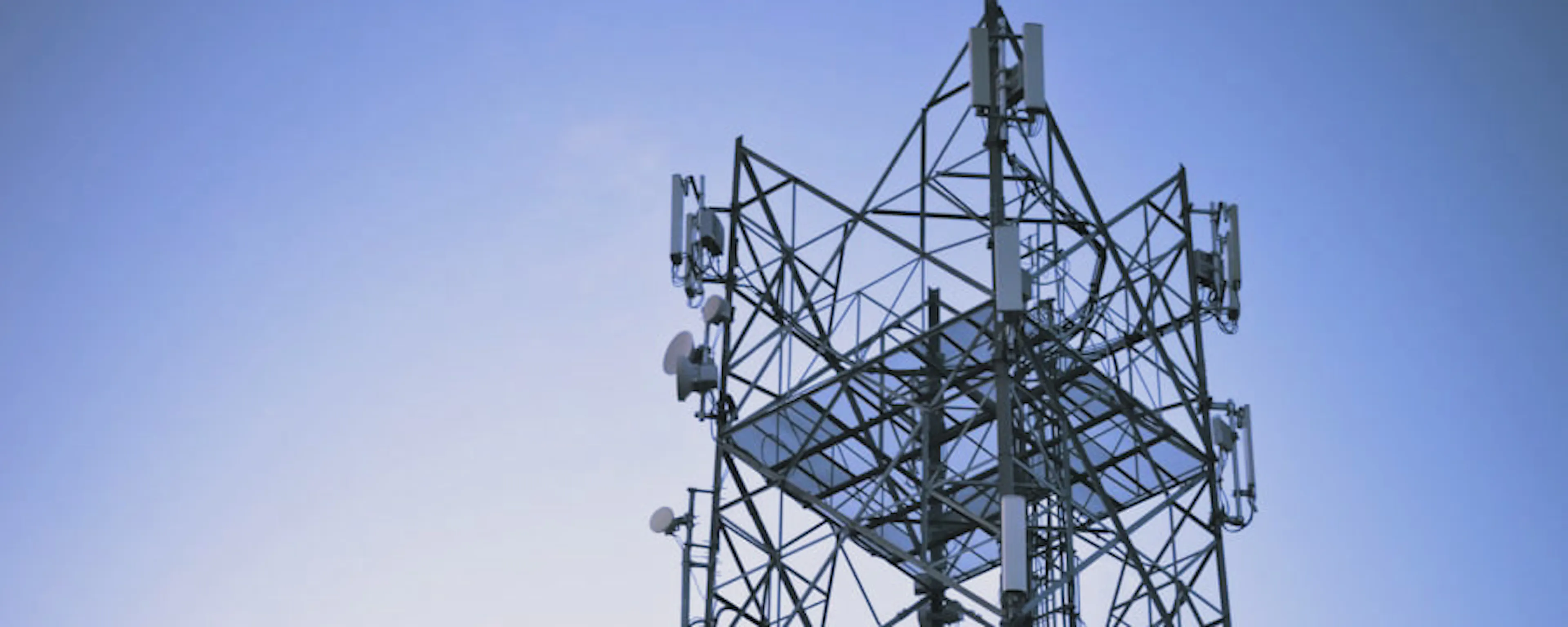 Lattice communications tower at dusk — P&R Communications