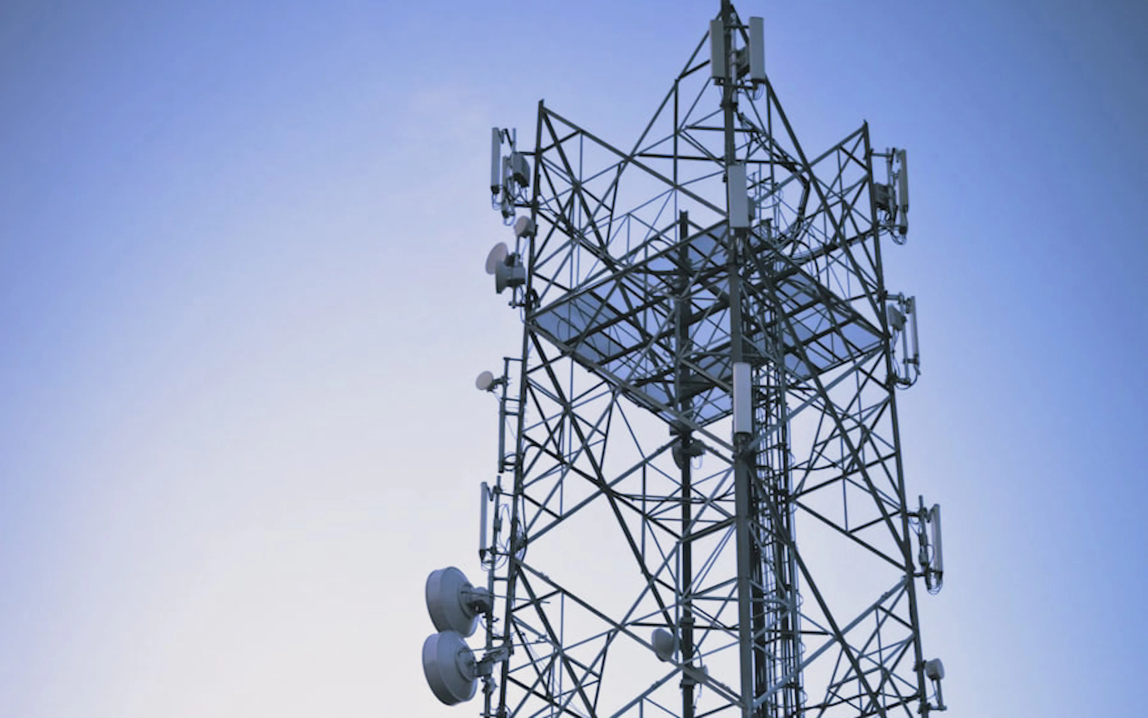 Lattice communications tower at dusk — P&R Communications