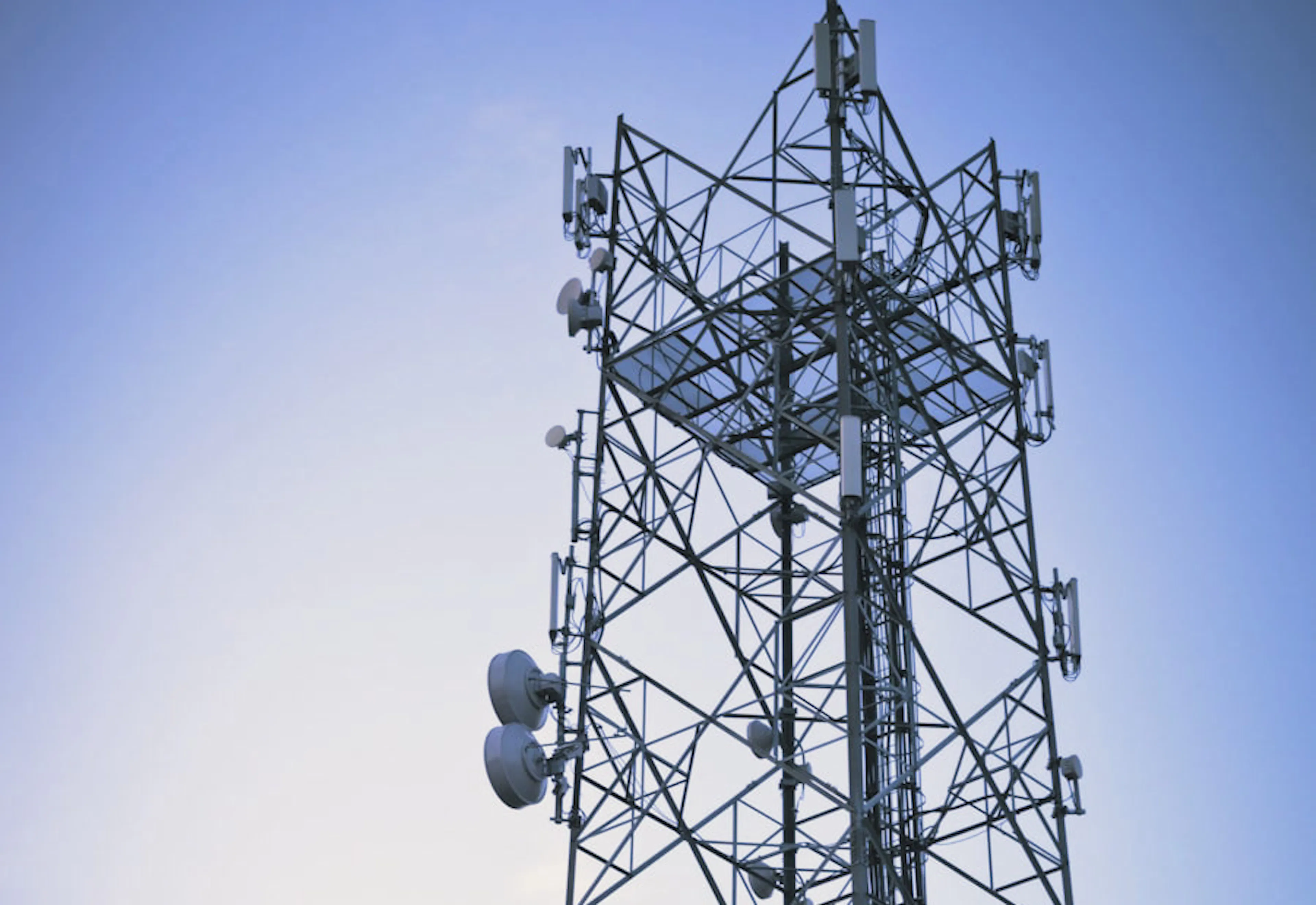 Lattice communications tower at dusk — P&R Communications