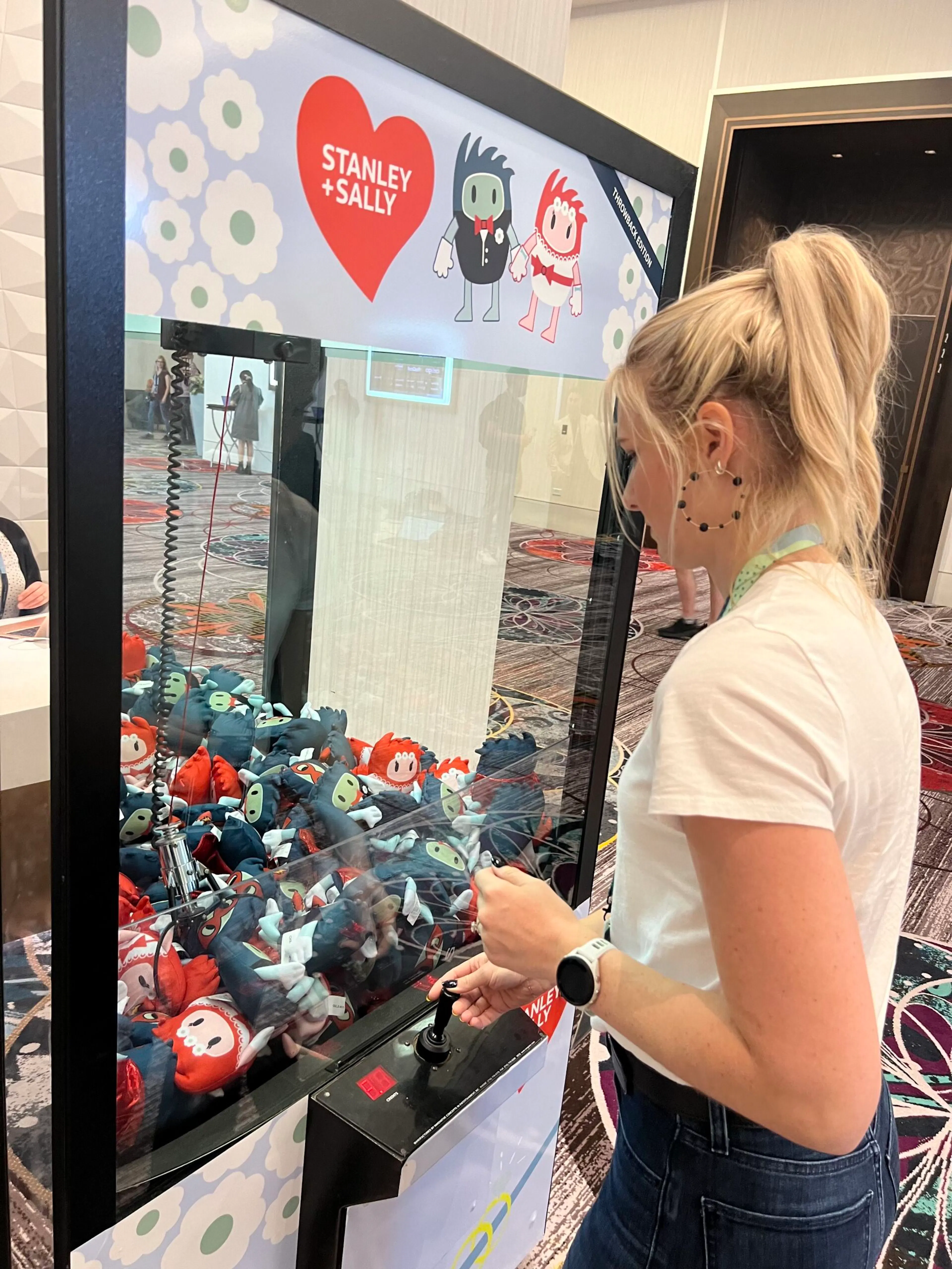 SuiteWorld attendee playing a branded claw machine at a vendor booth