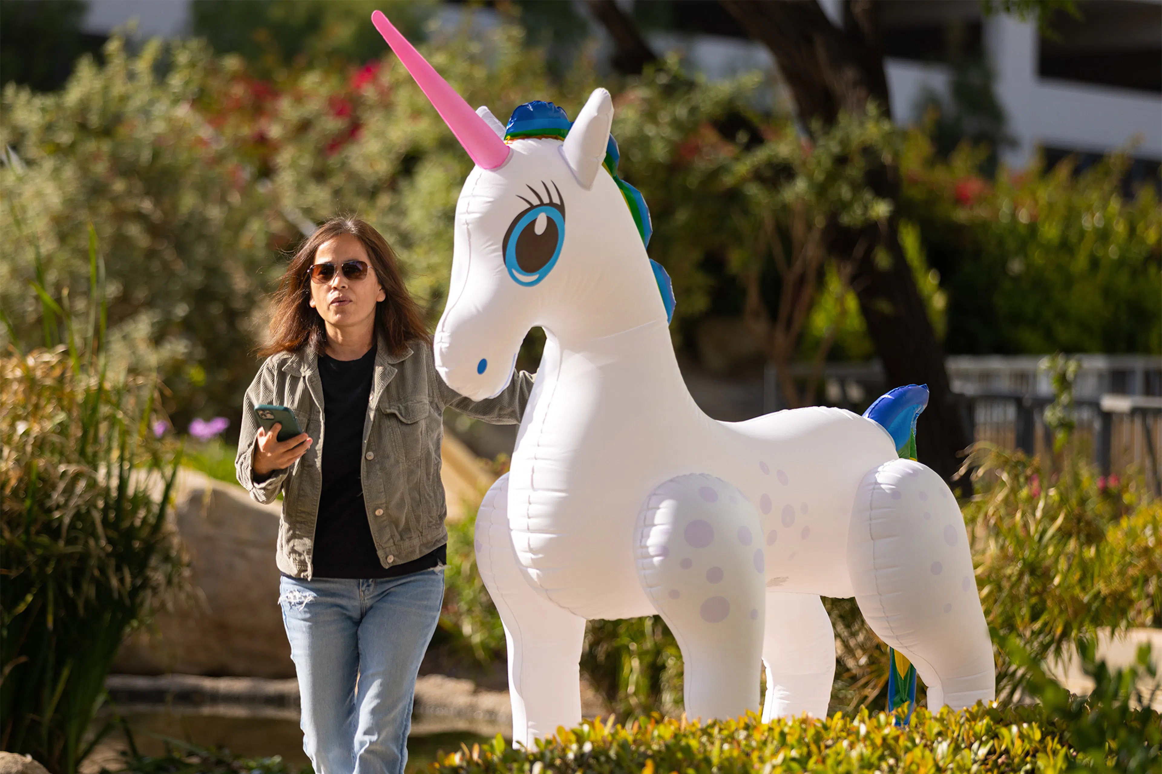 Luxent team member beside an inflatable unicorn at a company event