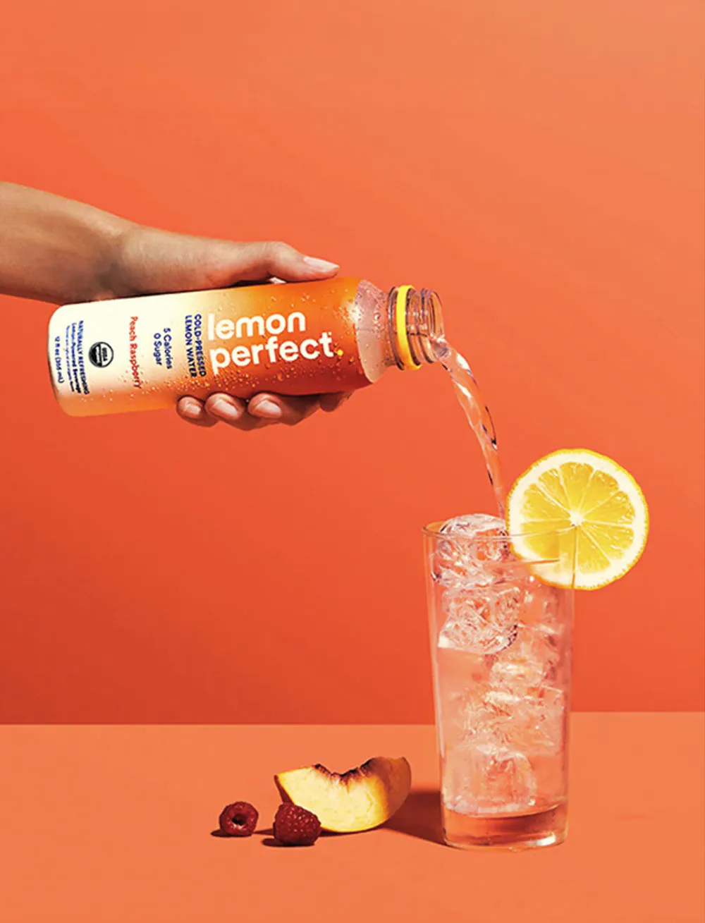 Lemon Perfect poured over ice in a glass with a lemon slice